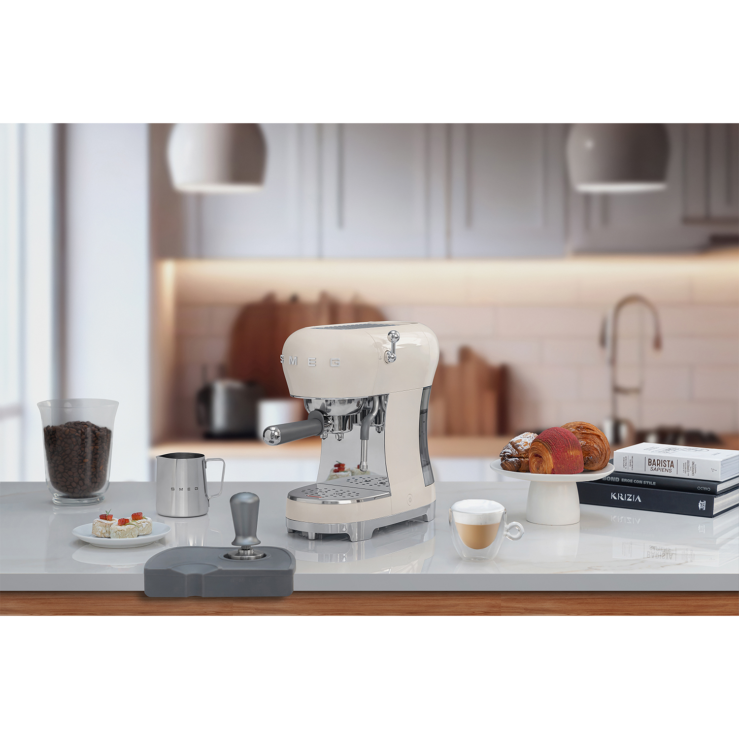 Macchina per espresso Smeg color crema con accessori per caffè su un piano di lavoro bianco.