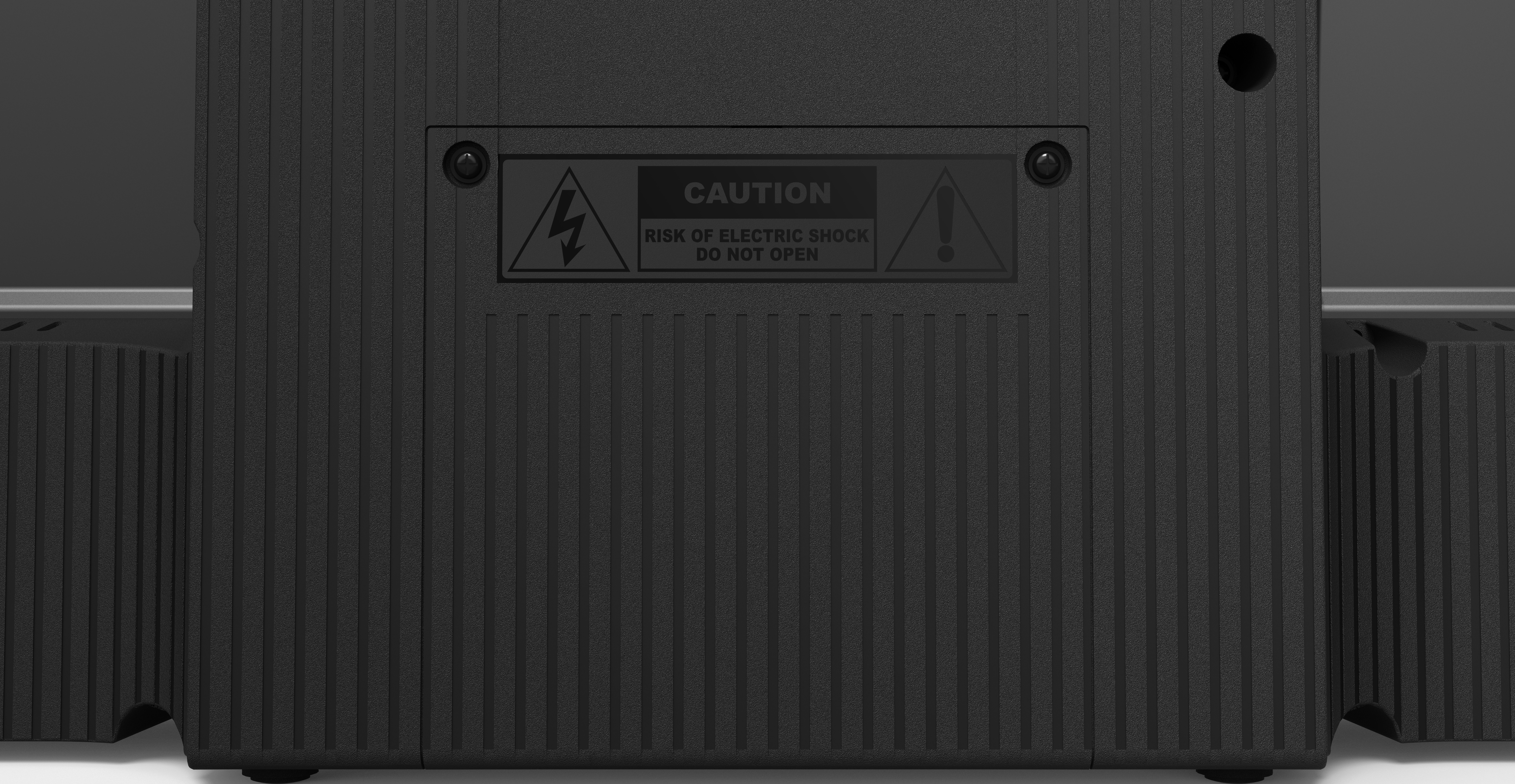 Appareil noir avec étiquette d'avertissement : attention, risque de choc électrique. Lignes verticales sur la surface. Vis visibles.