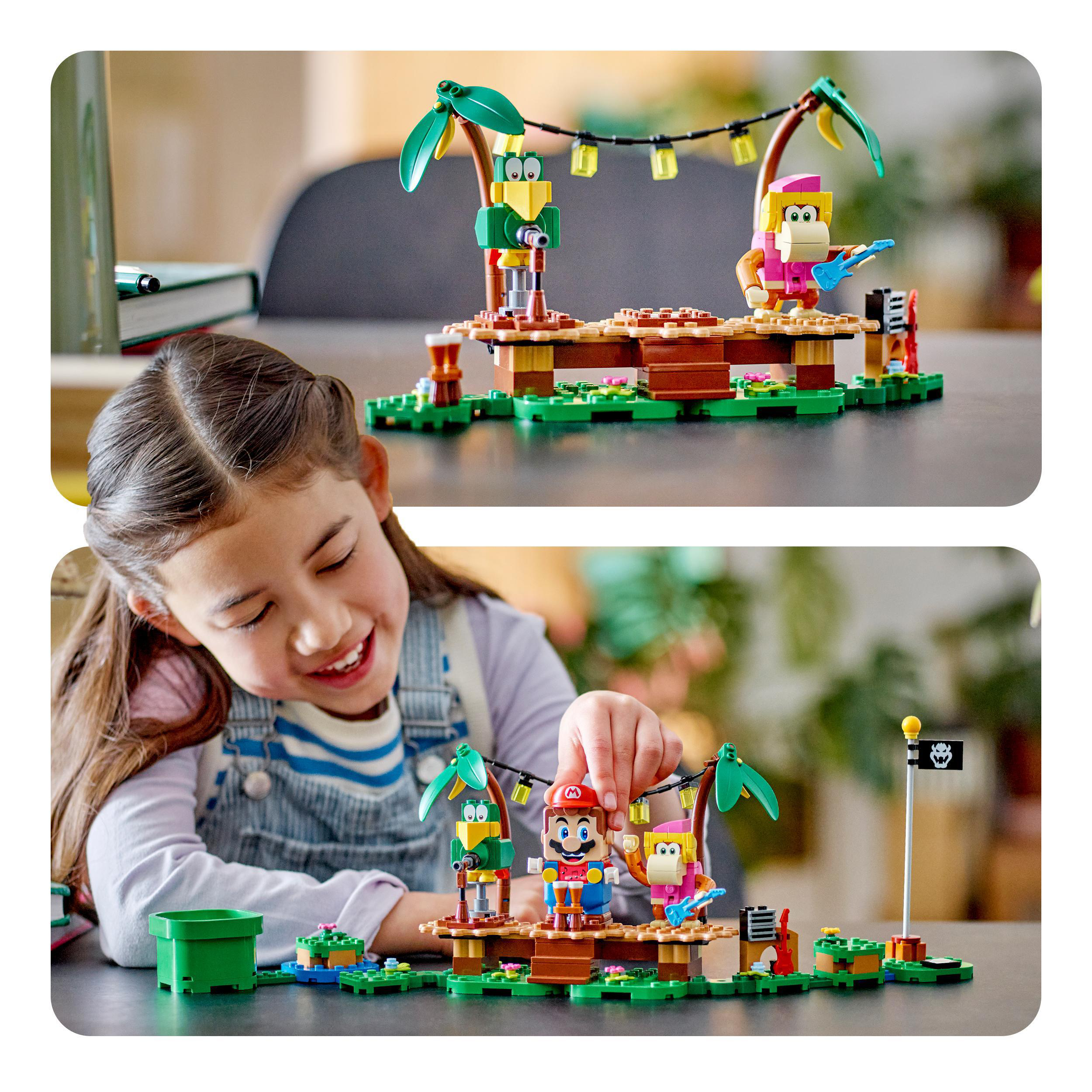 Ein Kind spielt mit einem Lego Mario Set. Das Set enthält Charaktere, eine Bühne und Palmen.