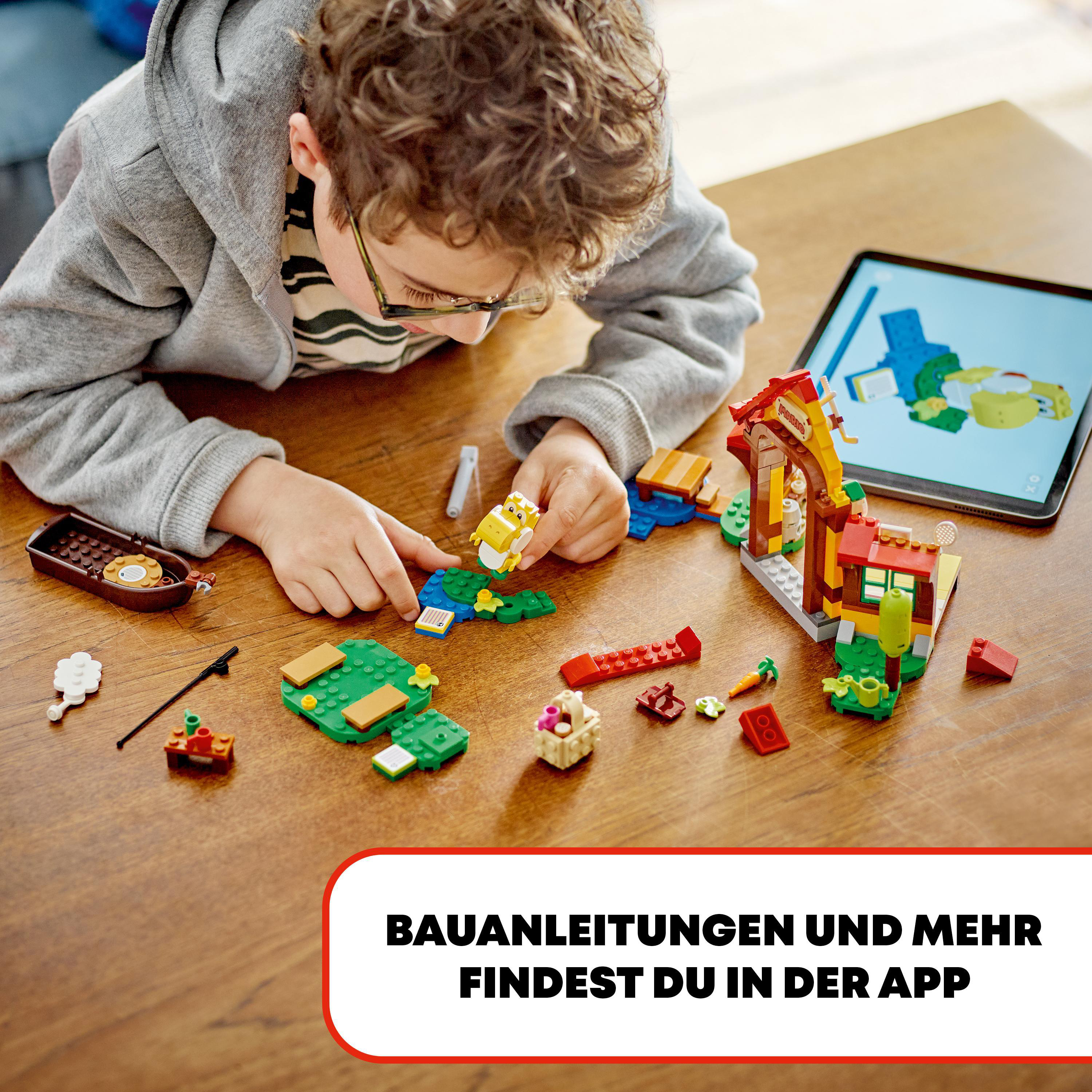 Ein junger Junge baut mit LEGO-Steinen auf einem Holztisch, mit einem Tablet, das Anweisungen zeigt.