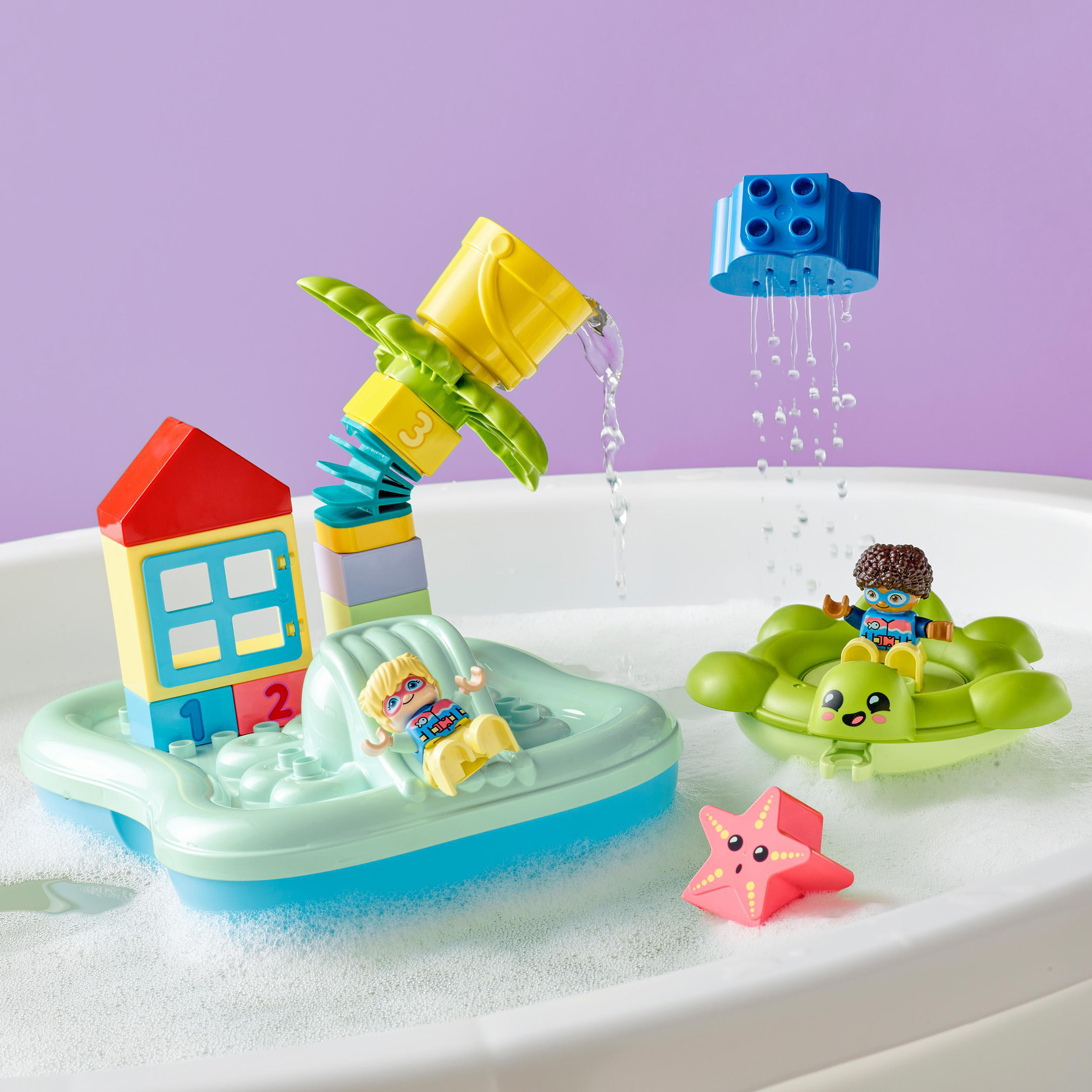 Lego-Wasserspielset mit Figuren in Booten, Wasserfall und Seestern in einer Wanne mit Blasen.
