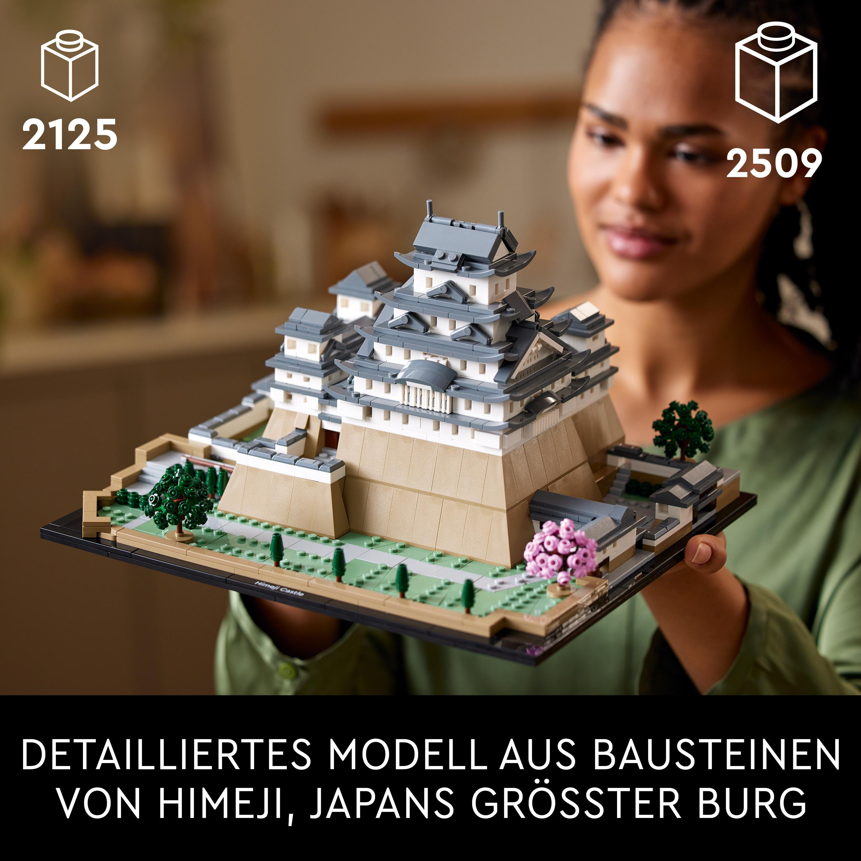 Eine Frau, die ein Lego-Modell einer japanischen Burg hält.