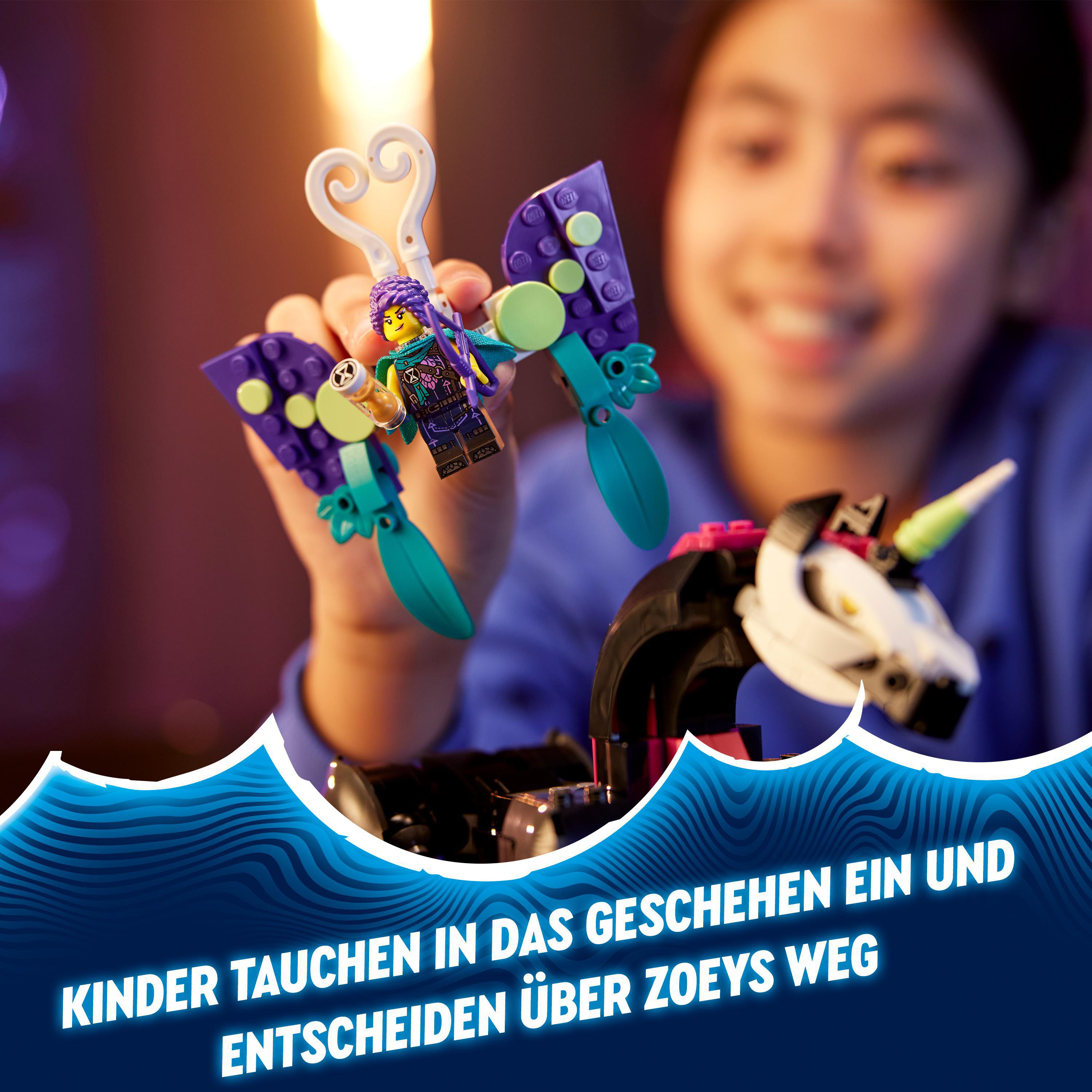 Ein Mädchen hält einen Lego-Schmetterling. Er ist lila, türkis und weiß. Unten sitzt ein Einhorn.