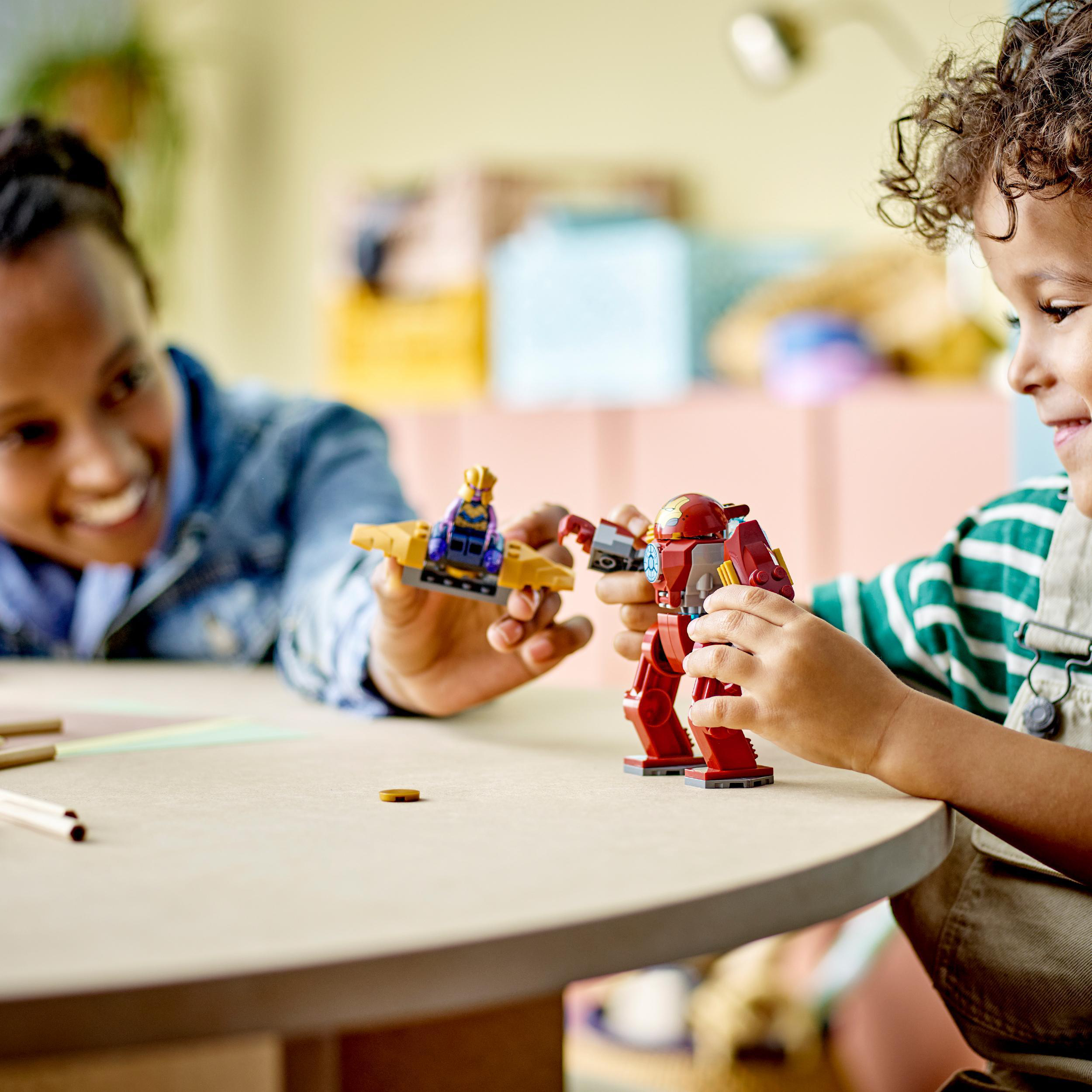 Mutter und Kind spielen mit Lego. Iron Man Roboter und kleines Flugteil.