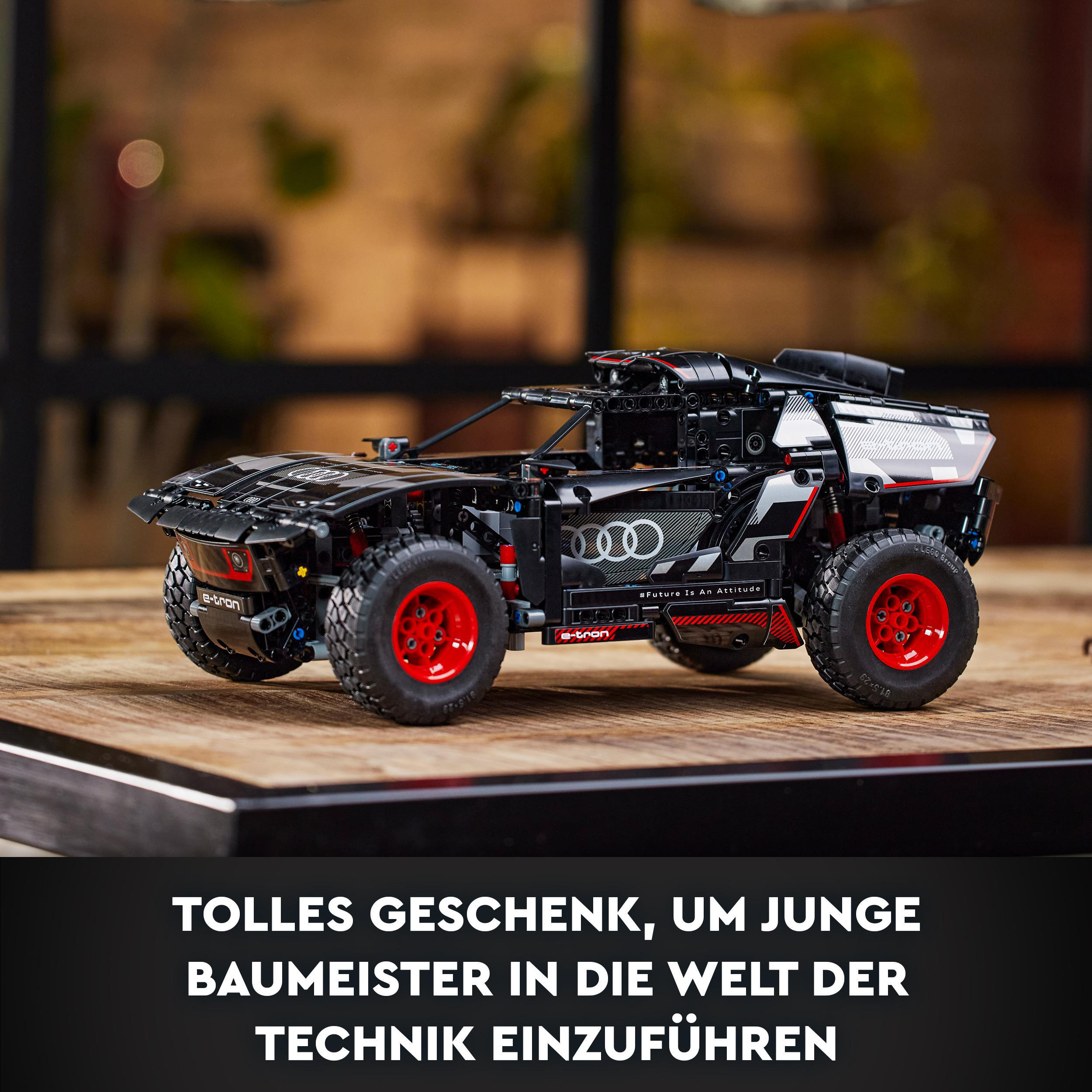 Ein Lego Technic Automodell mit roten Rädern auf einer Holzoberfläche, schwarzes Auto.