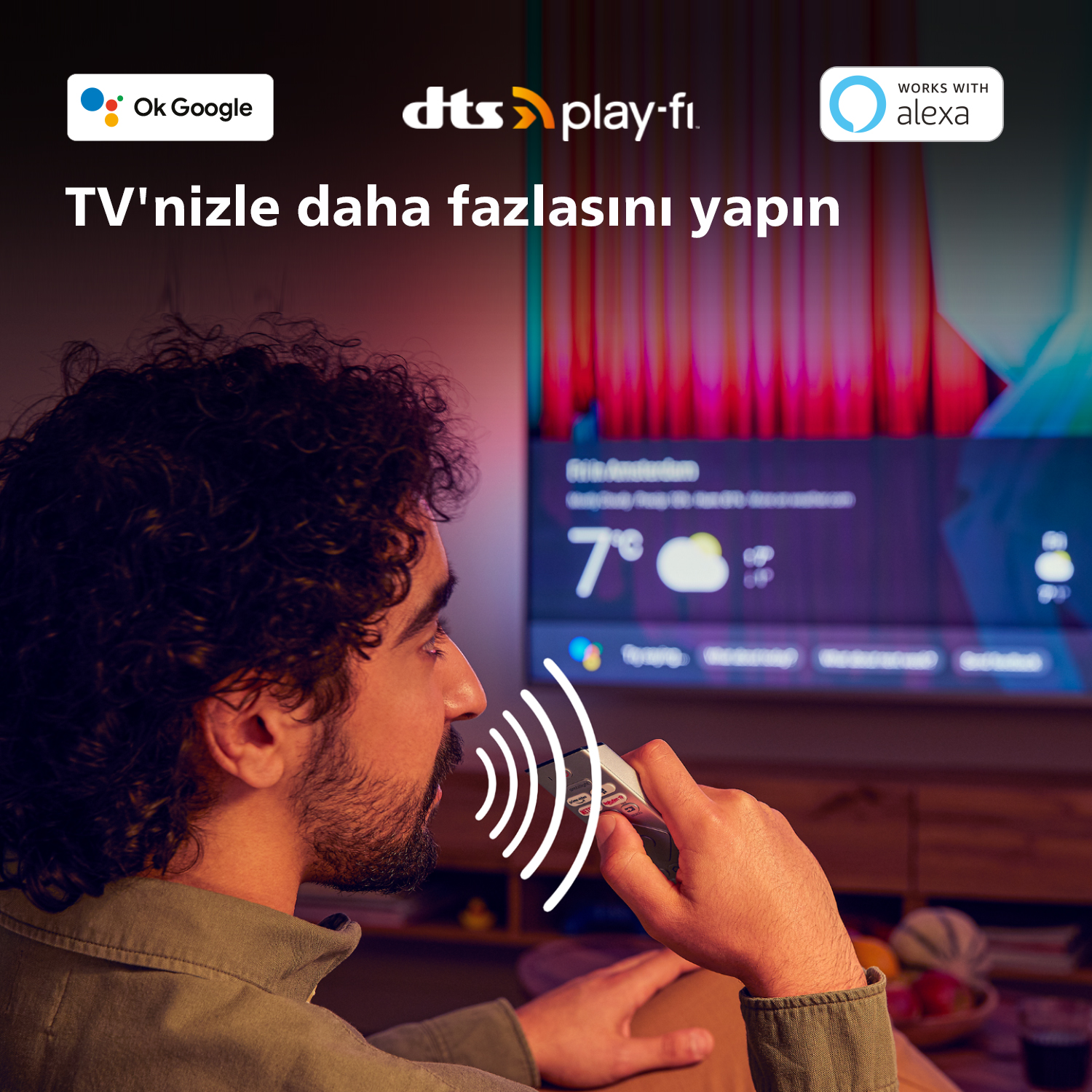 Adam uzaktan kumandaya konuşuyor, arka planda hava durumu bilgisi olan TV, Ok Google, Alexa ve DTS logoları.