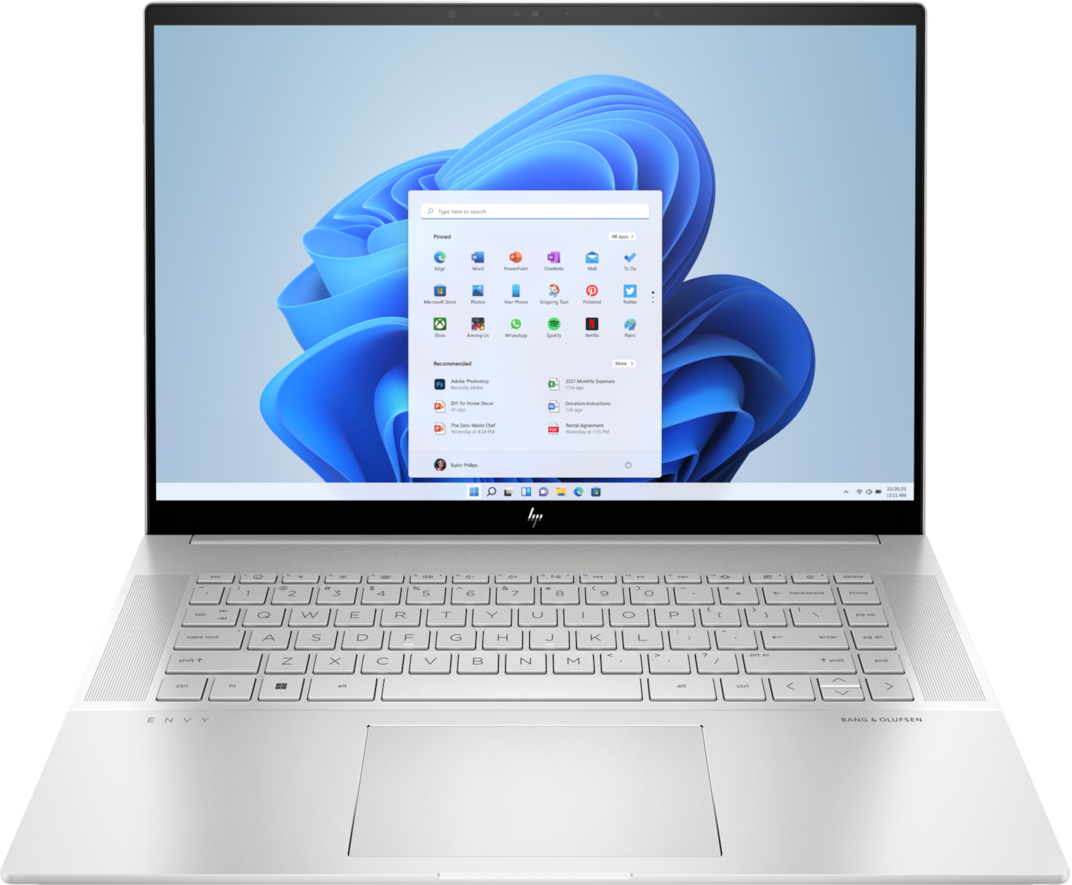 Un ordinateur portable HP Envy argenté. L'écran affiche un bureau Windows 11 avec des icônes d'applications. Clavier et pavé tactile visibles.