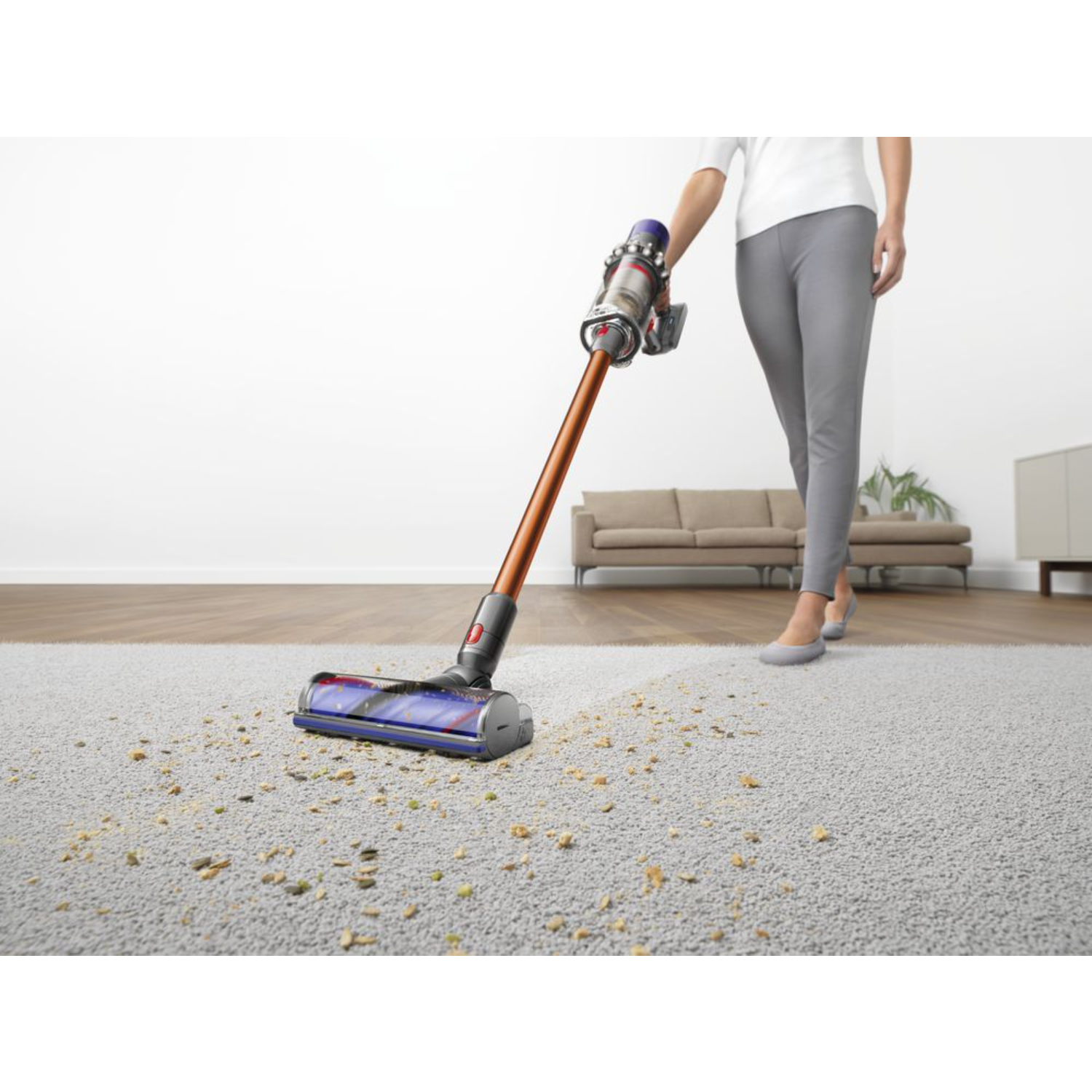Persoon stofzuigt een tapijt met een Dyson stofzuiger. Het tapijt is vuil.
