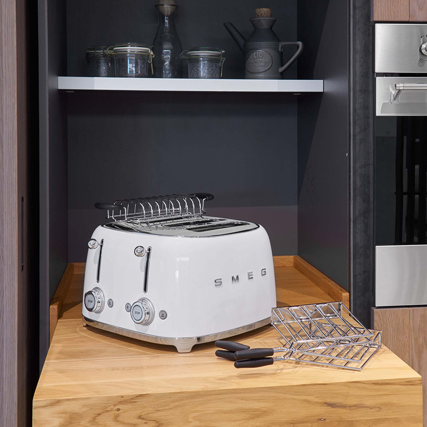 Un tostapane Smeg bianco con due fessure e una griglia, posto su una superficie di legno.