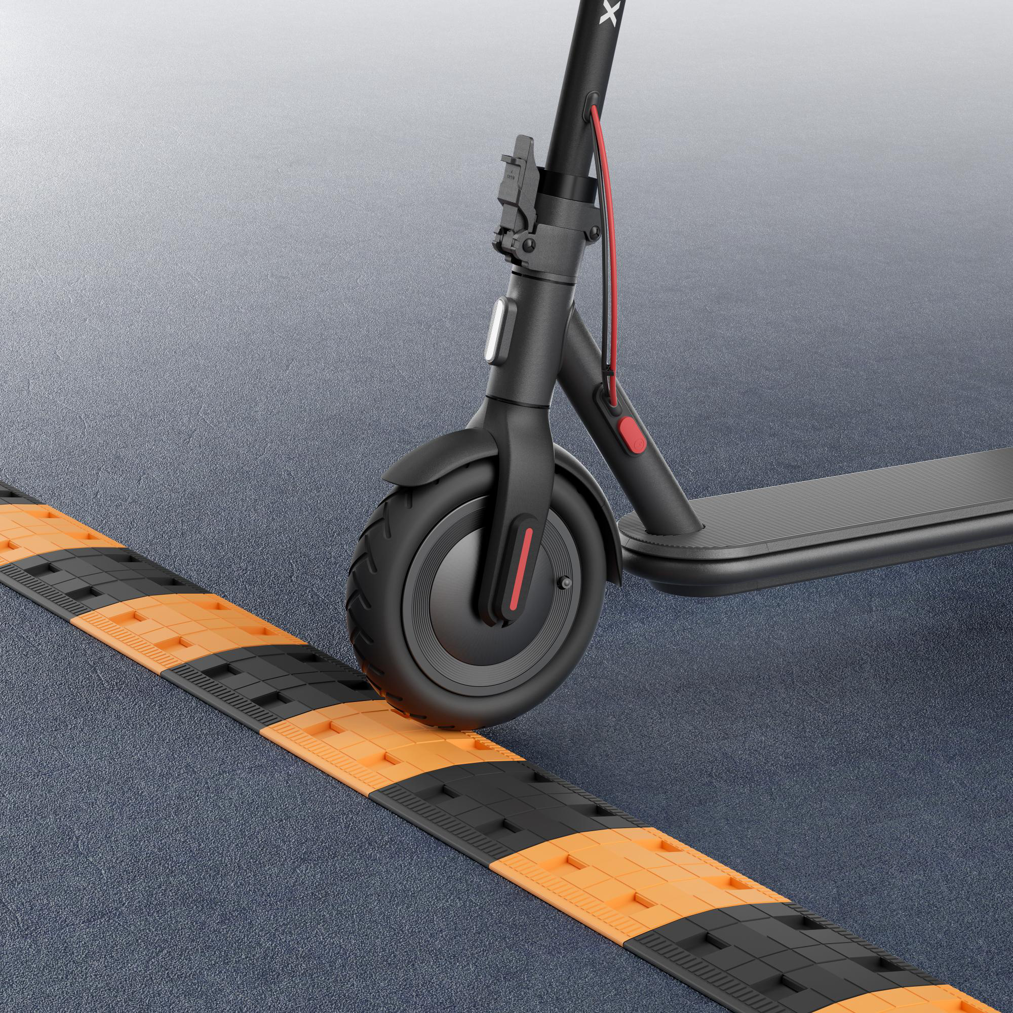 Schwarzer Roller auf grauer Oberfläche, nähert sich einer orange gestreiften Bodenwelle.