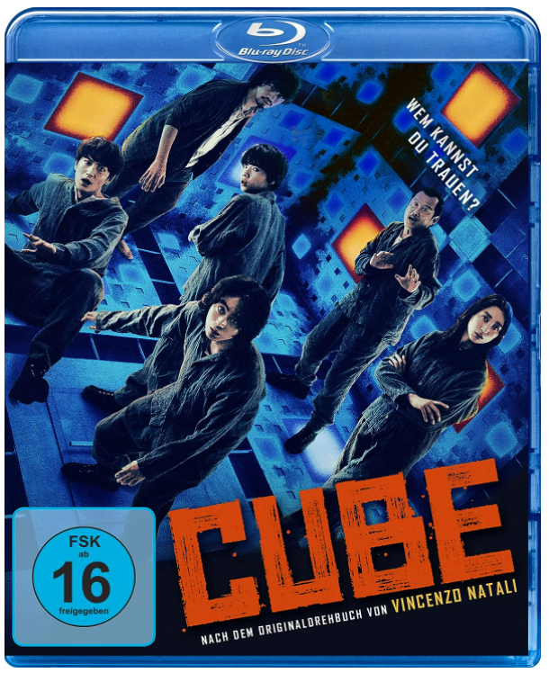 Sechs Personen in dunkler Kleidung in einem würfelförmigen Raum mit blauem und orangem Licht.