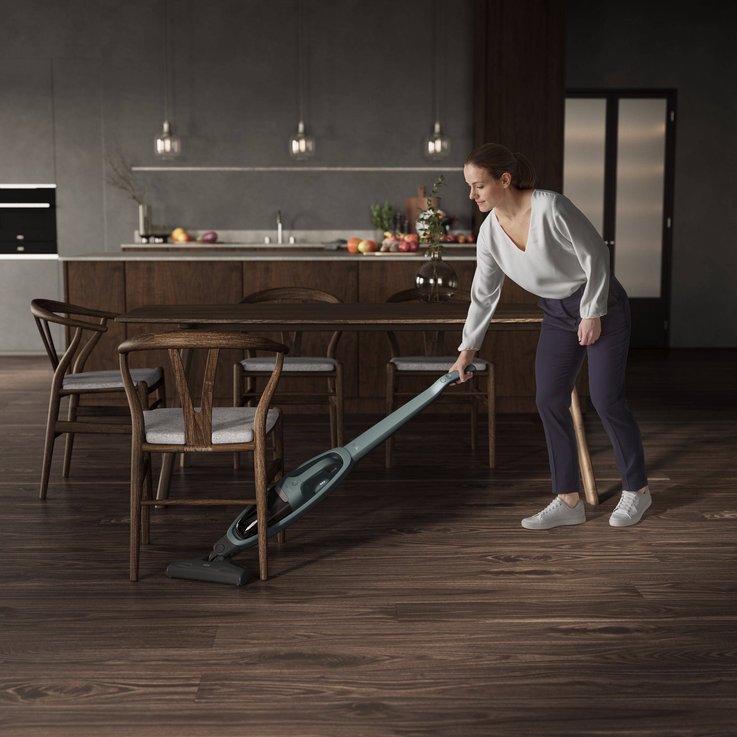 Frau, die einen Holzboden mit einem kabellosen Staubsauger saugt.