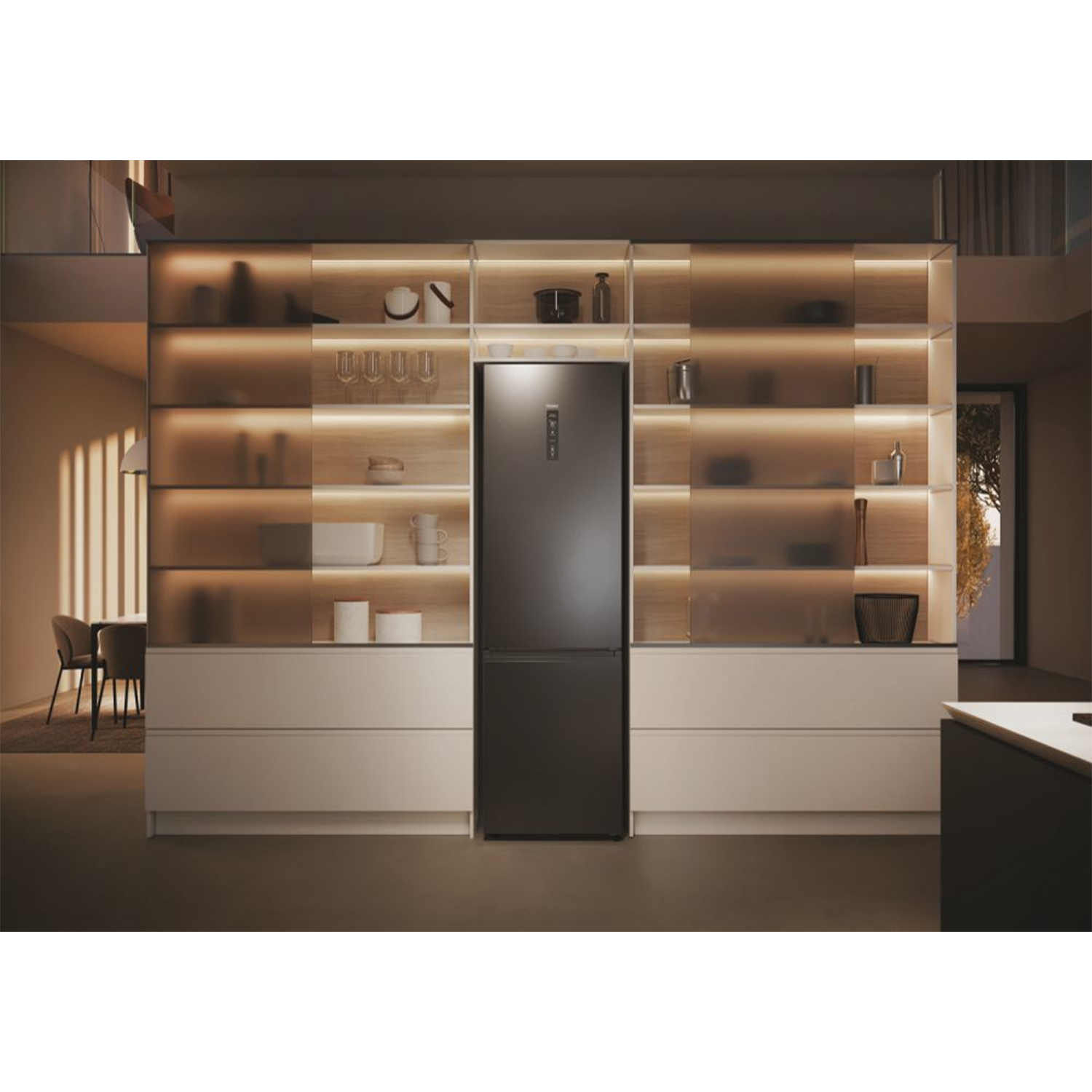 Un frigorifero nero in una cucina con mobili bianchi e mensole in legno, illuminato da luci calde.