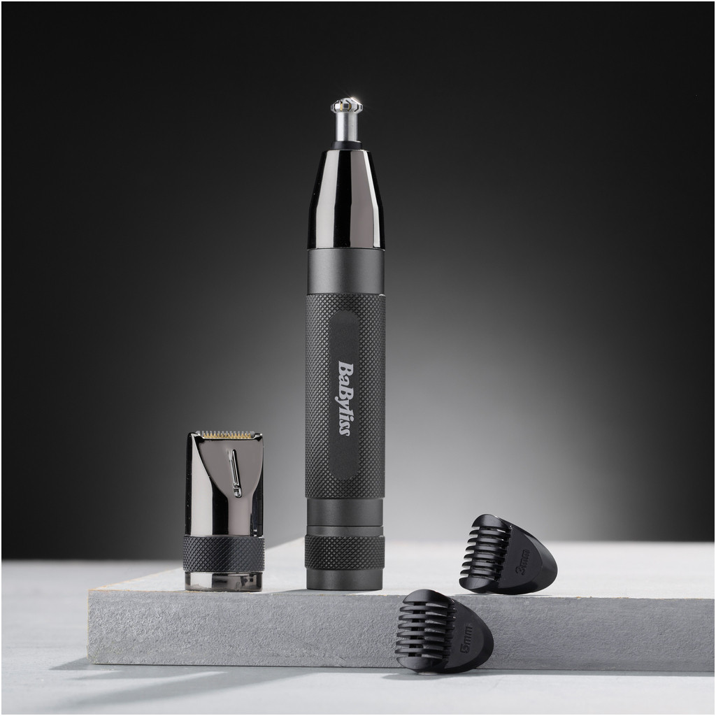Trois outils de toilettage noirs sur une surface grise. Un est un coupe-bordure, deux sont des accessoires.