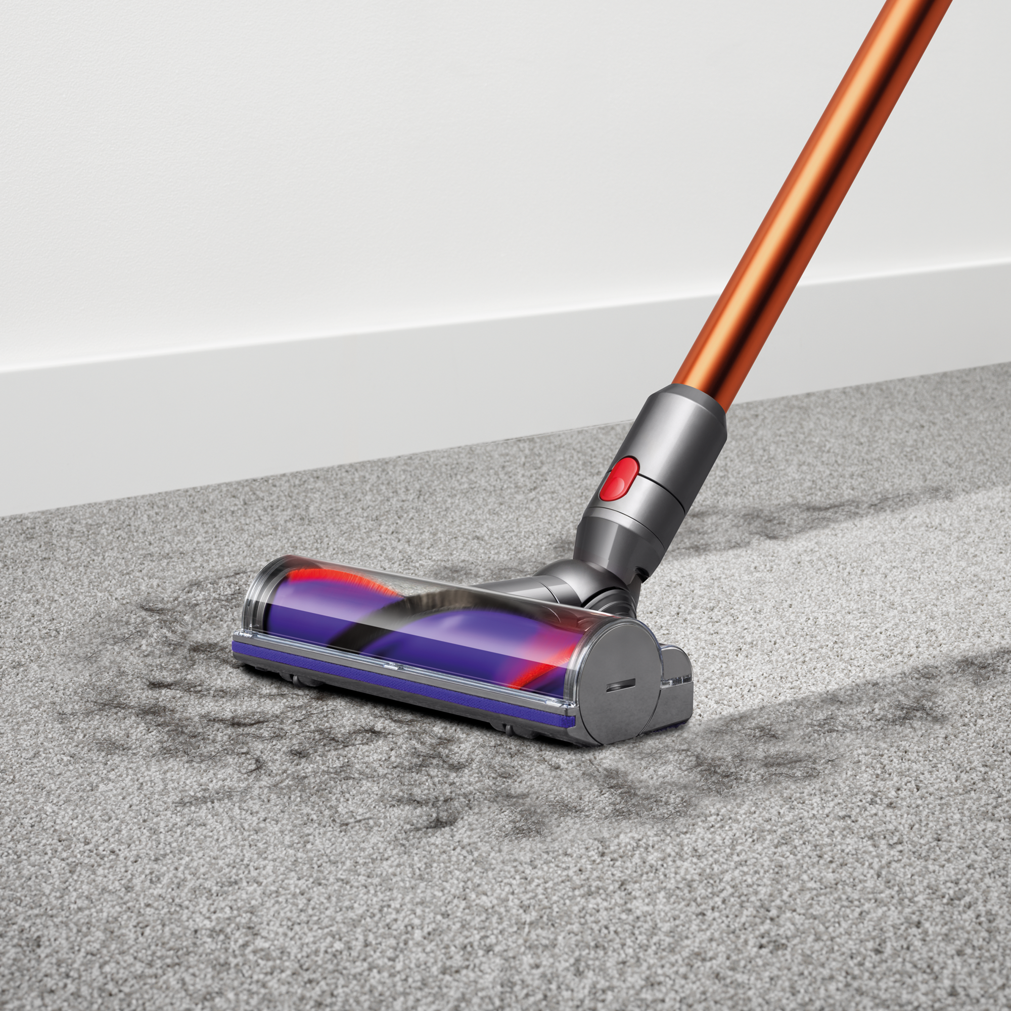 Dyson-Staubsaugerkopf reinigt einen grauen Teppich.