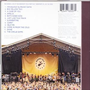 Rückseite einer CD-Hülle. Bühnenbild mit Publikum, Band und Text mit Songtiteln.