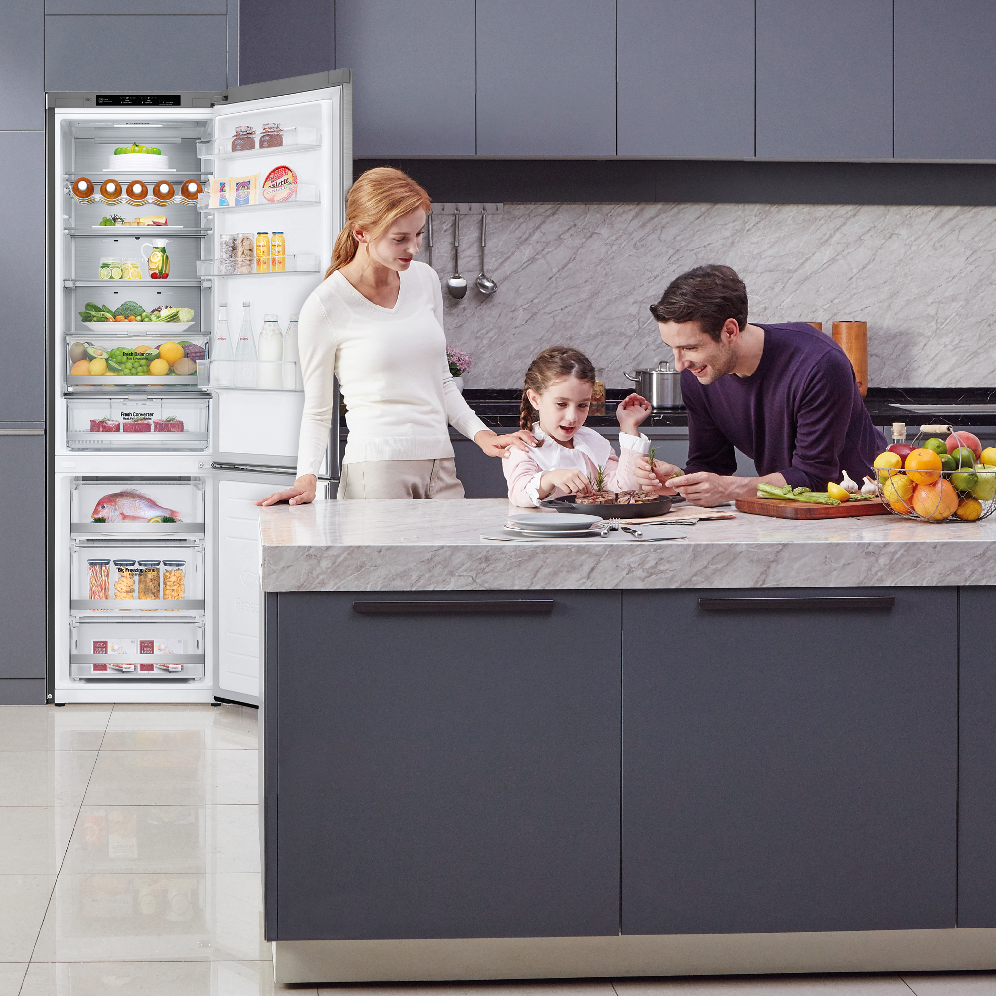Familia en una cocina con nevera abierta y encimera con comida.