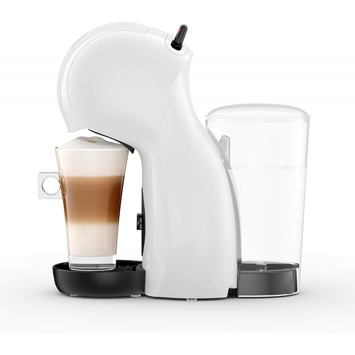 Una cafetera blanca con un vaso de café en capas y un recipiente de agua al lado.