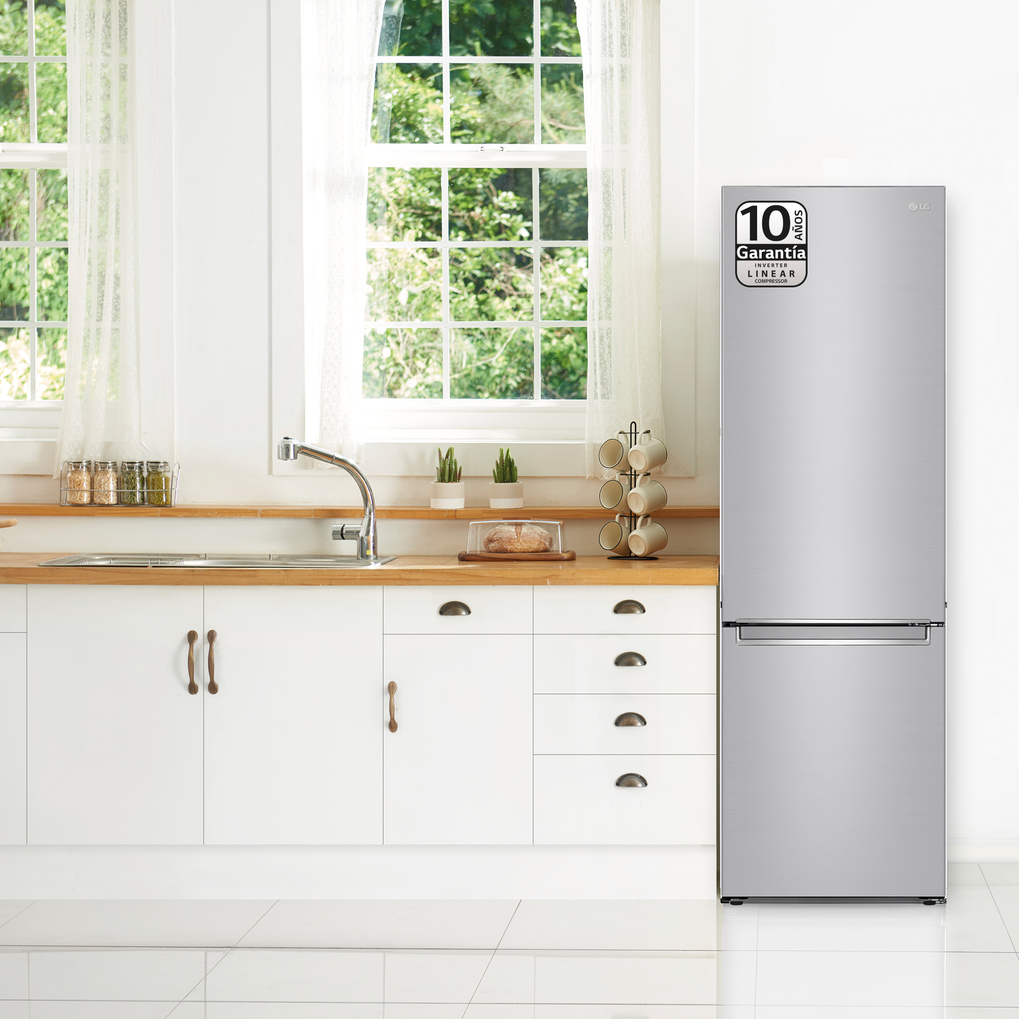 Un refrigerador LG plateado en una cocina con gabinetes blancos y encimeras de madera.