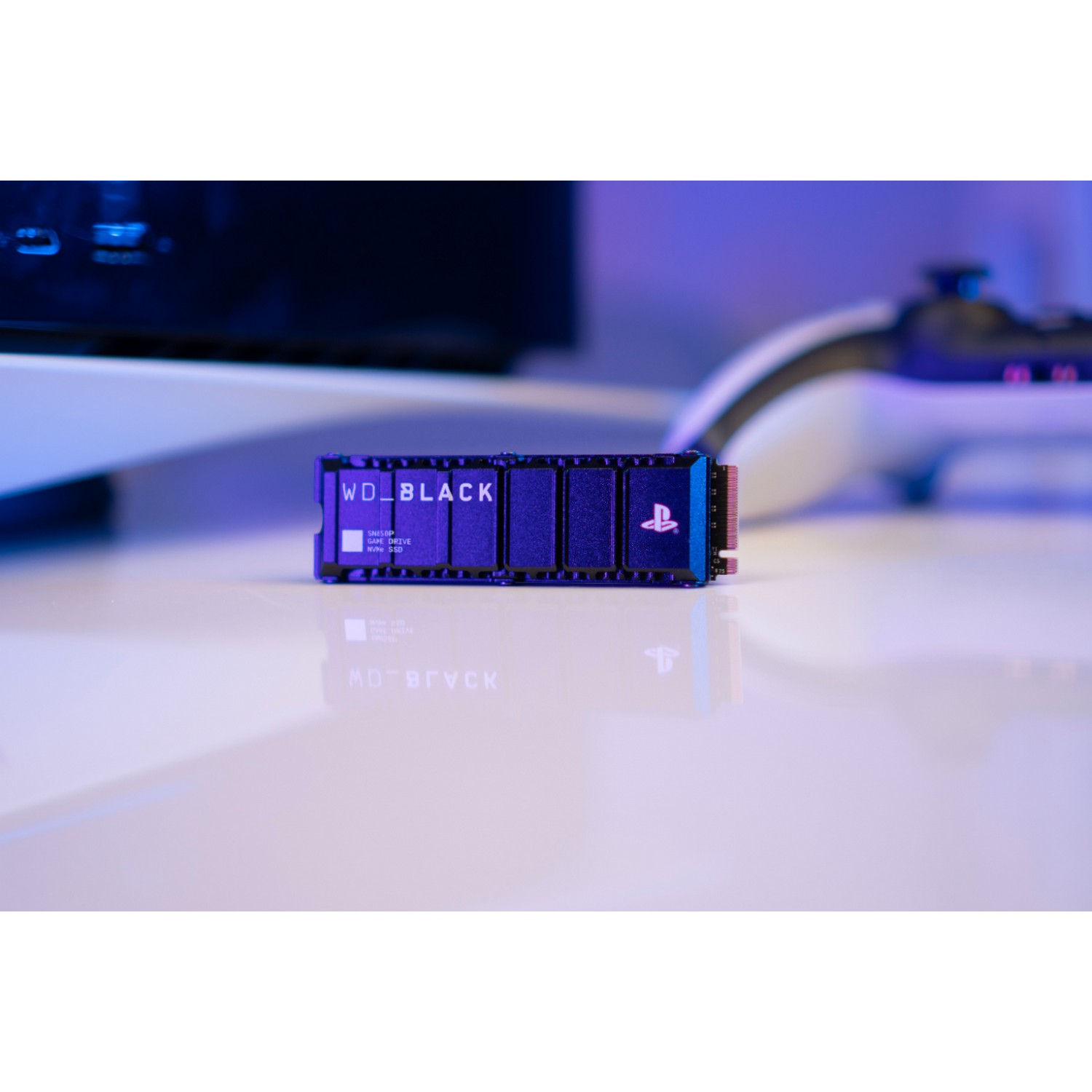 Un SSD NVMe WD_BLACK negro sobre una superficie blanca con un controlador y logo PlayStation.