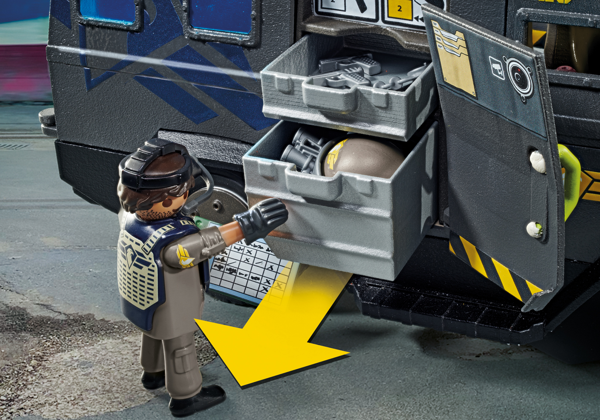 Eine Playmobil-Figur öffnet eine Schublade an einem Polizeifahrzeug und gibt Werkzeuge frei.