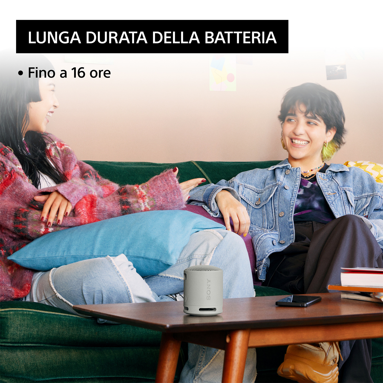 Due donne con un altoparlante, testo in alto: 'Lunga durata della batteria' e testo: 'Fino a 16 ore'.