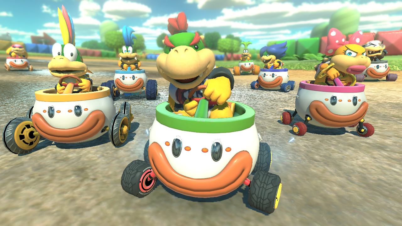 Mario Kart characters in their karts racing on a track, with Bowser Jr. in the lead. 