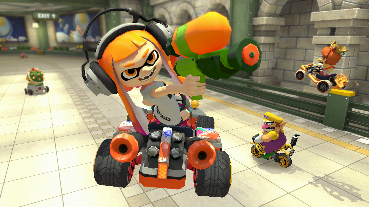A group of characters in Mario Kart racing on a track, with an Inkling girl in a kart.