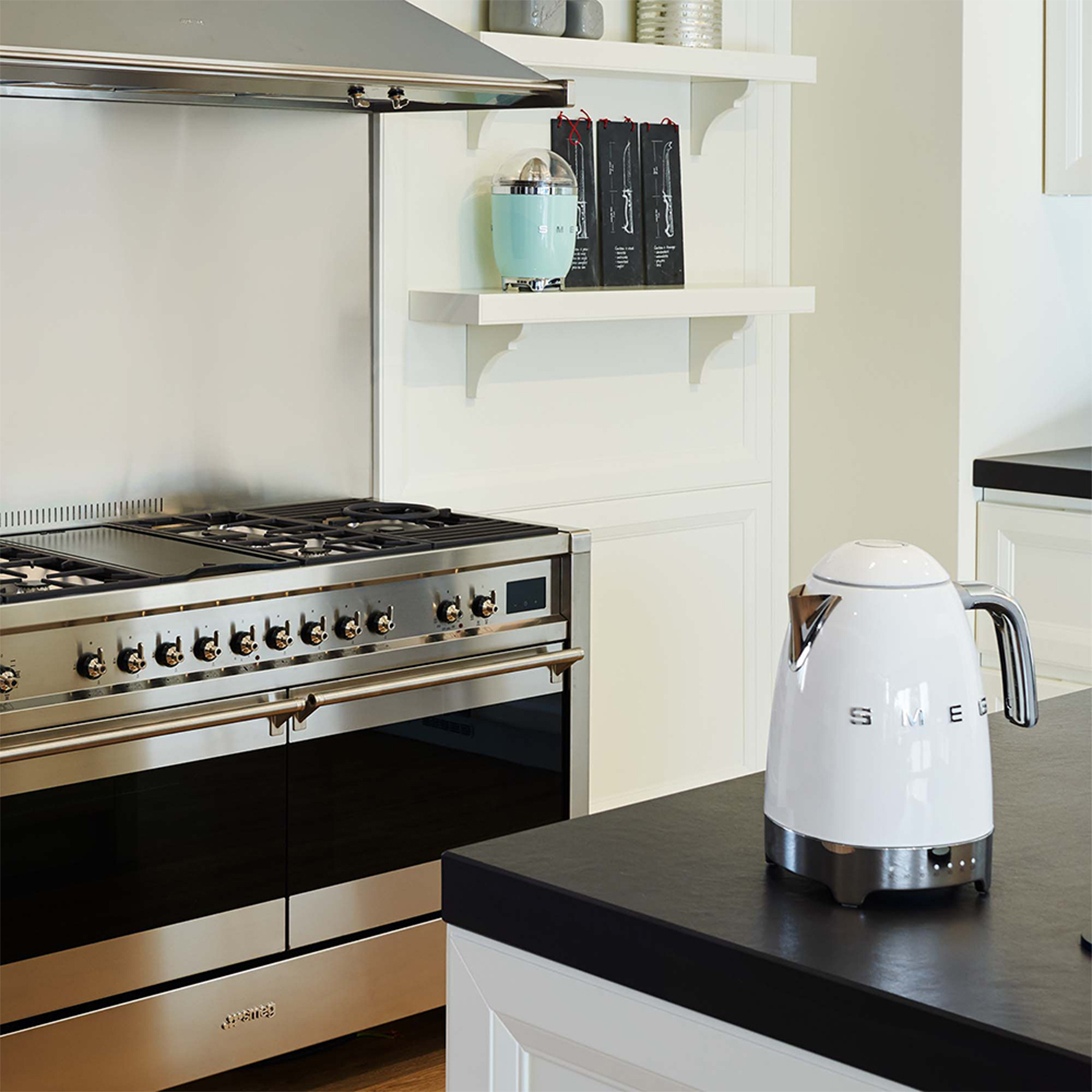 Scena cucina con un bollitore bianco su un piano nero.