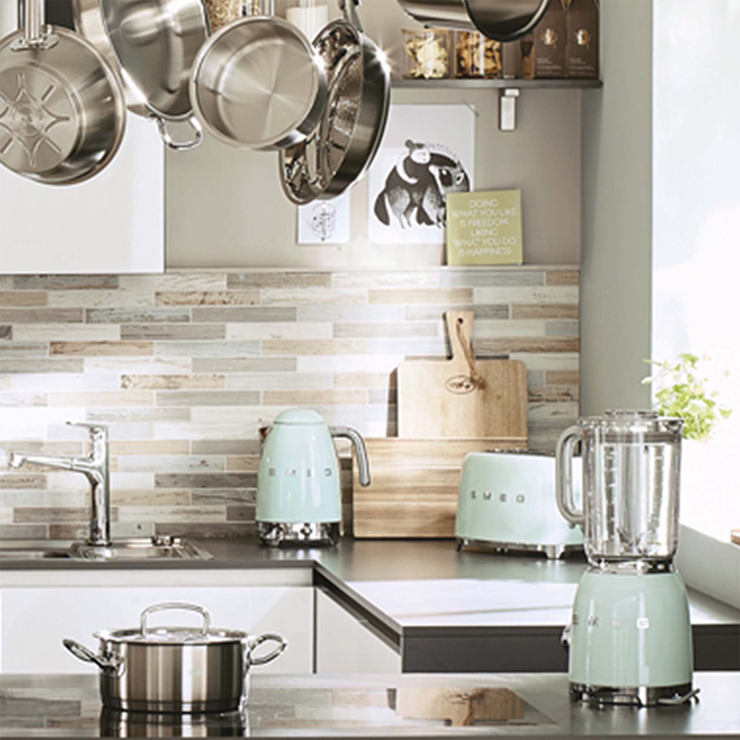 Una scena di cucina con vari elettrodomestici e utensili nei colori verde menta e acciaio inossidabile.