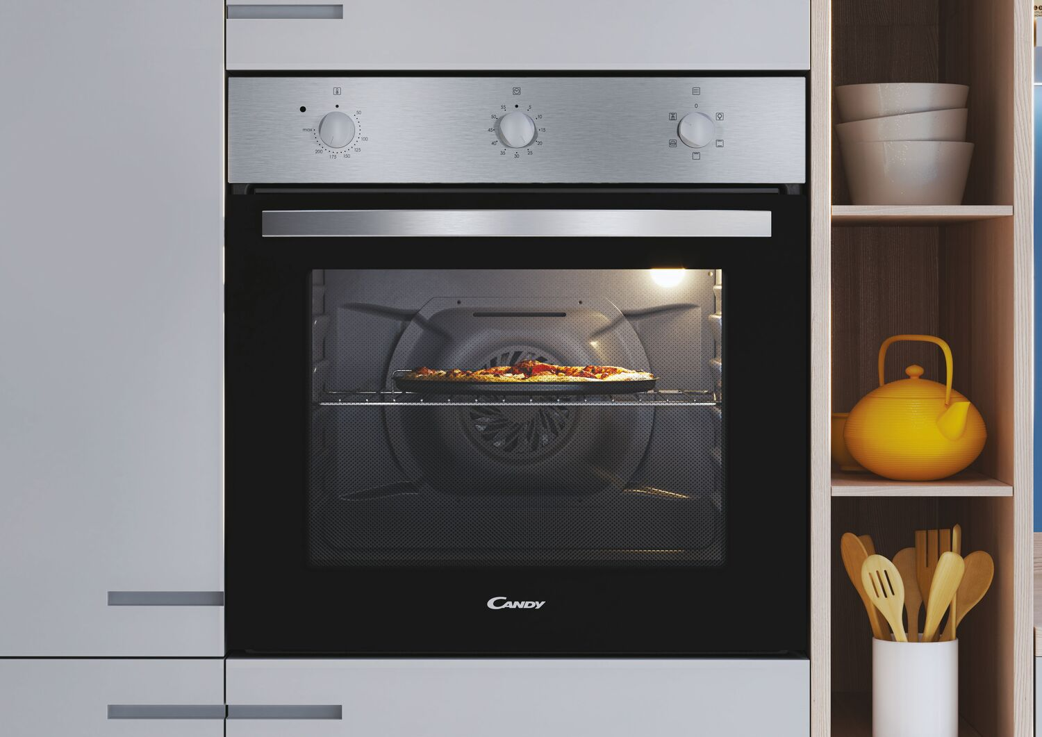 Horno con pizza dentro, frente de acero inoxidable, estante de madera y tetera amarilla.