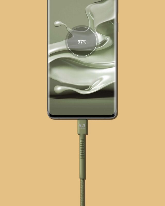 Telefon w trakcie ładowania. Telefon pokazuje 97% naładowania. Widoczny zielony kabel i ładowarka.