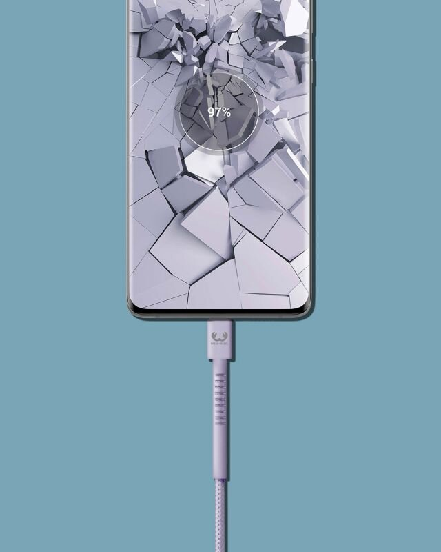 Telefon w trakcie ładowania, wyświetlający 97%. Telefon otoczony jest rozbitym szkłem.