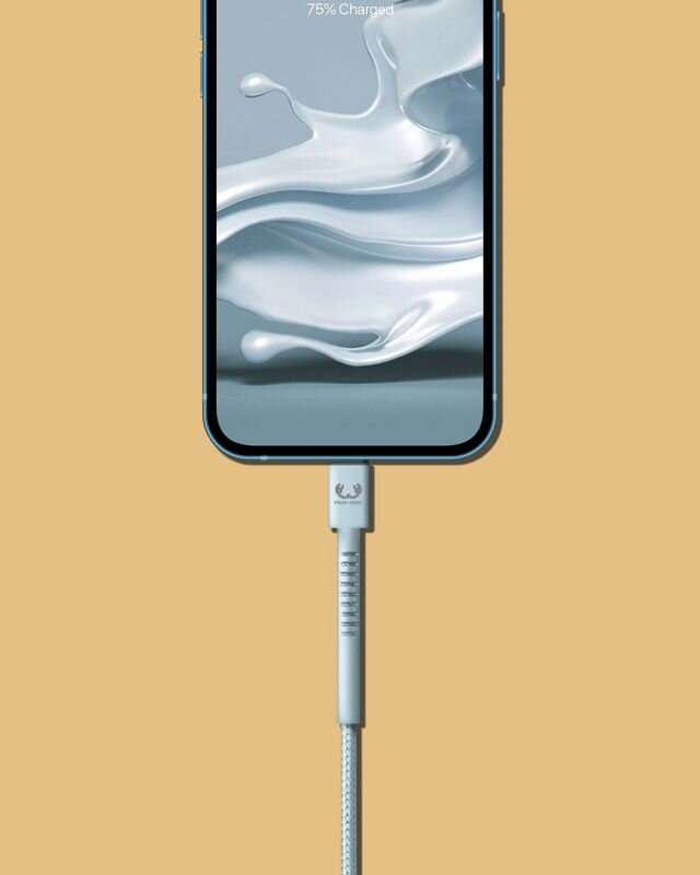 Jasnoniebieski telefon ładujący się jasnoniebieskim kablem, tło jest pomarańczowe.