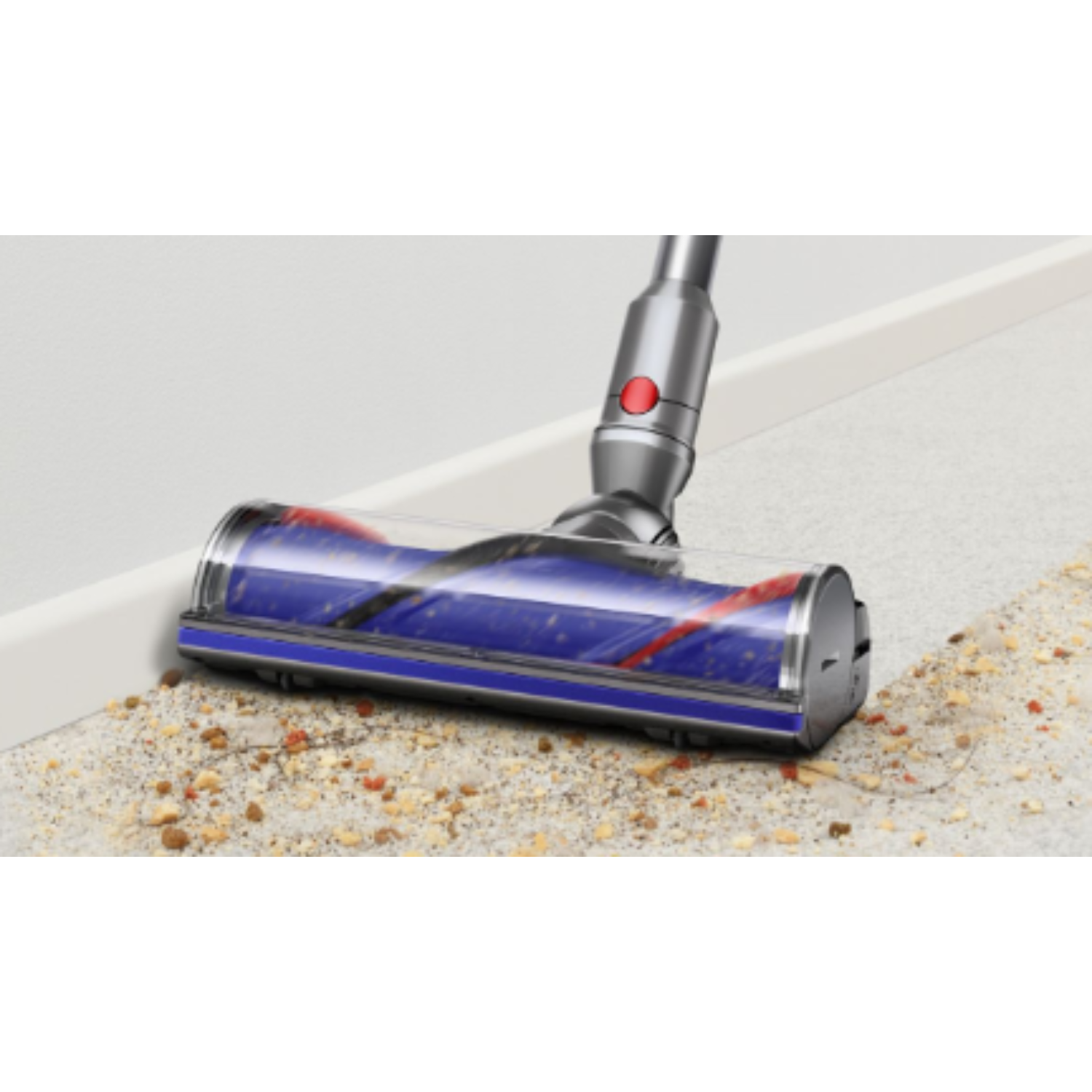 Dyson vacuum cleaner head on the floor with debris. Red and blue rollers are visible.