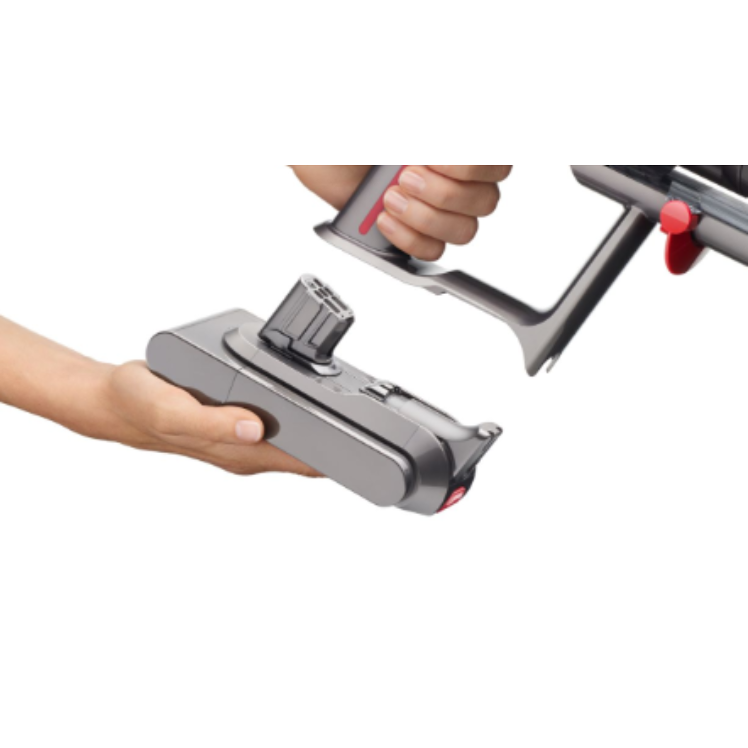 Hands assembling a handheld vacuum cleaner. One hand holds the handle, the other the body.