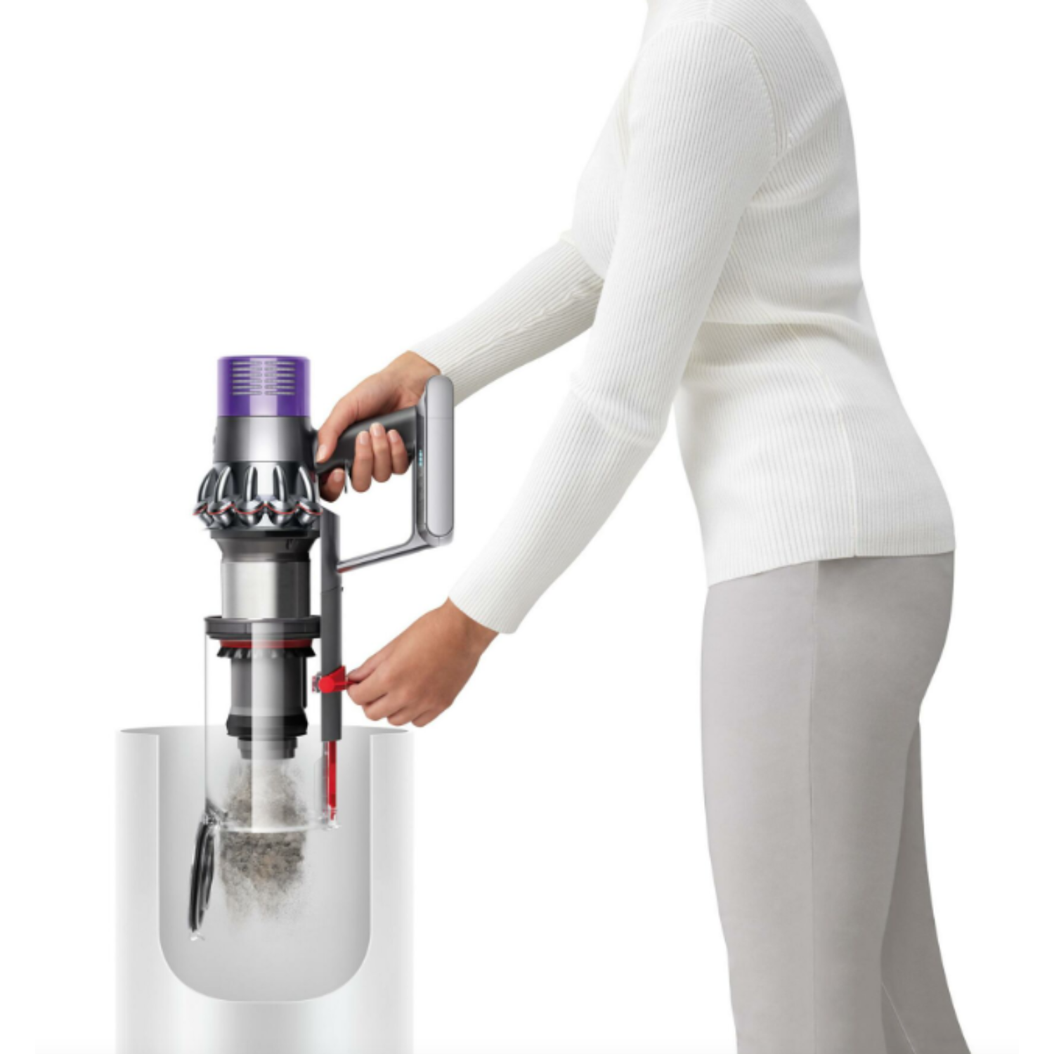 A woman uses a Dyson vacuum. The vacuum is in a container with hair and dirt.