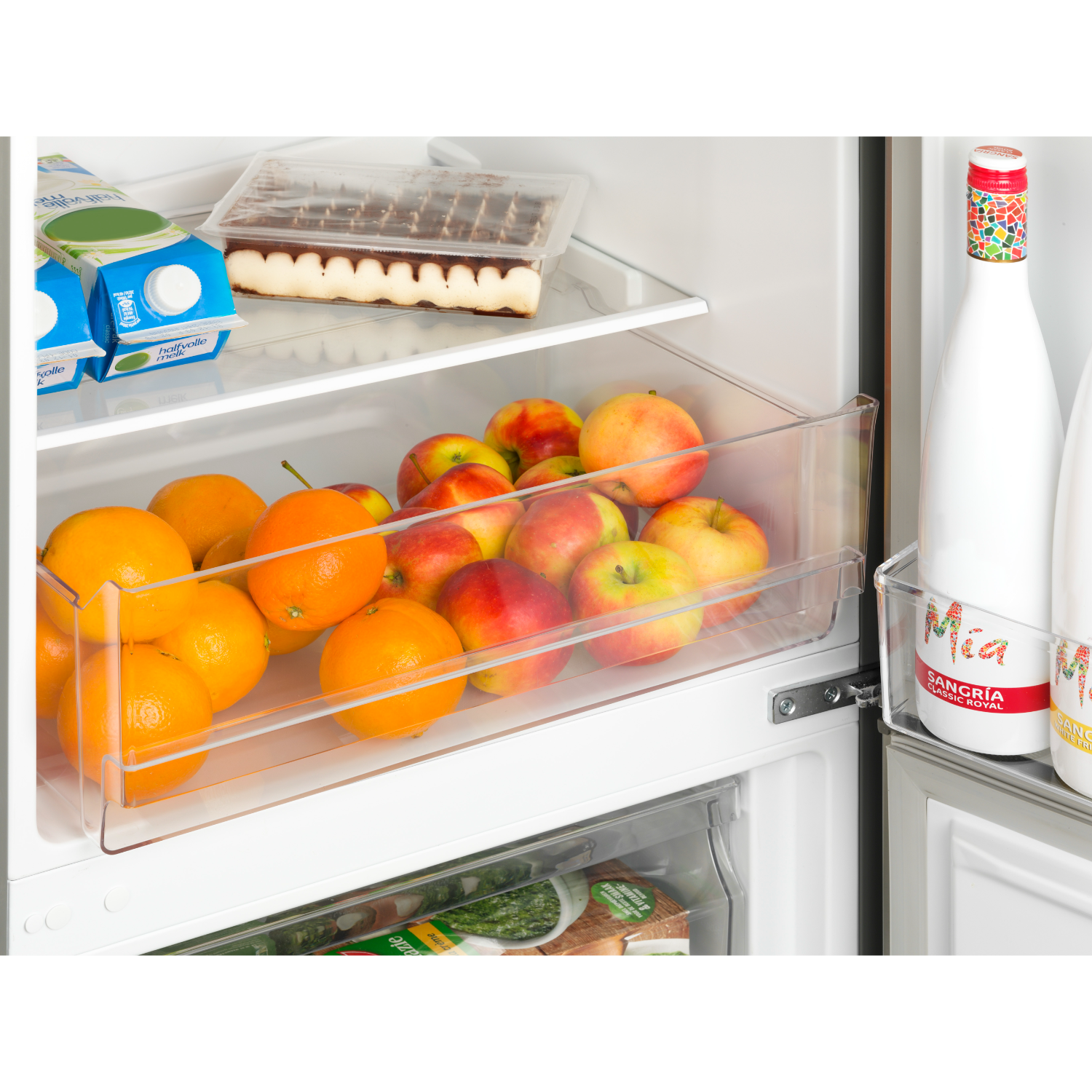 Refrigerator interior filled with fruits, juice cartons, and bottles of sangria.