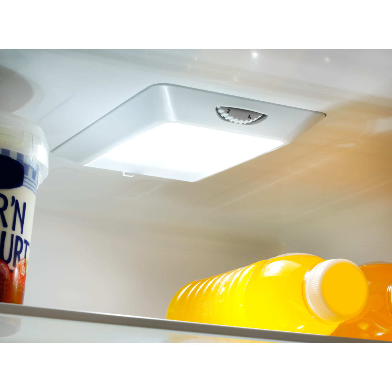 Interior of a refrigerator with a light fixture and food items, including juice and yogurt.