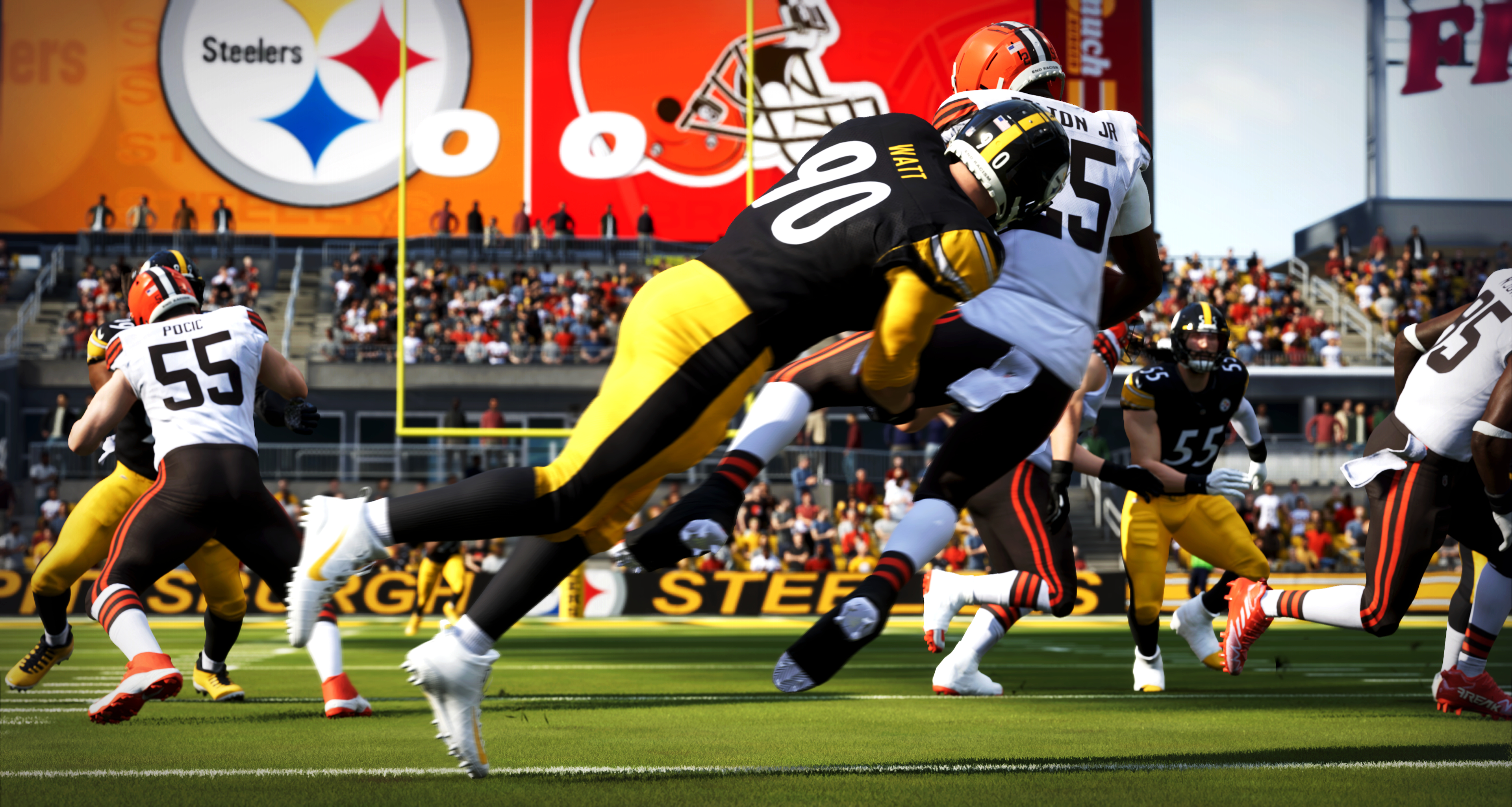 Footballspieler in Aktion auf grünem Feld, mit Logos und Stadiondetails.