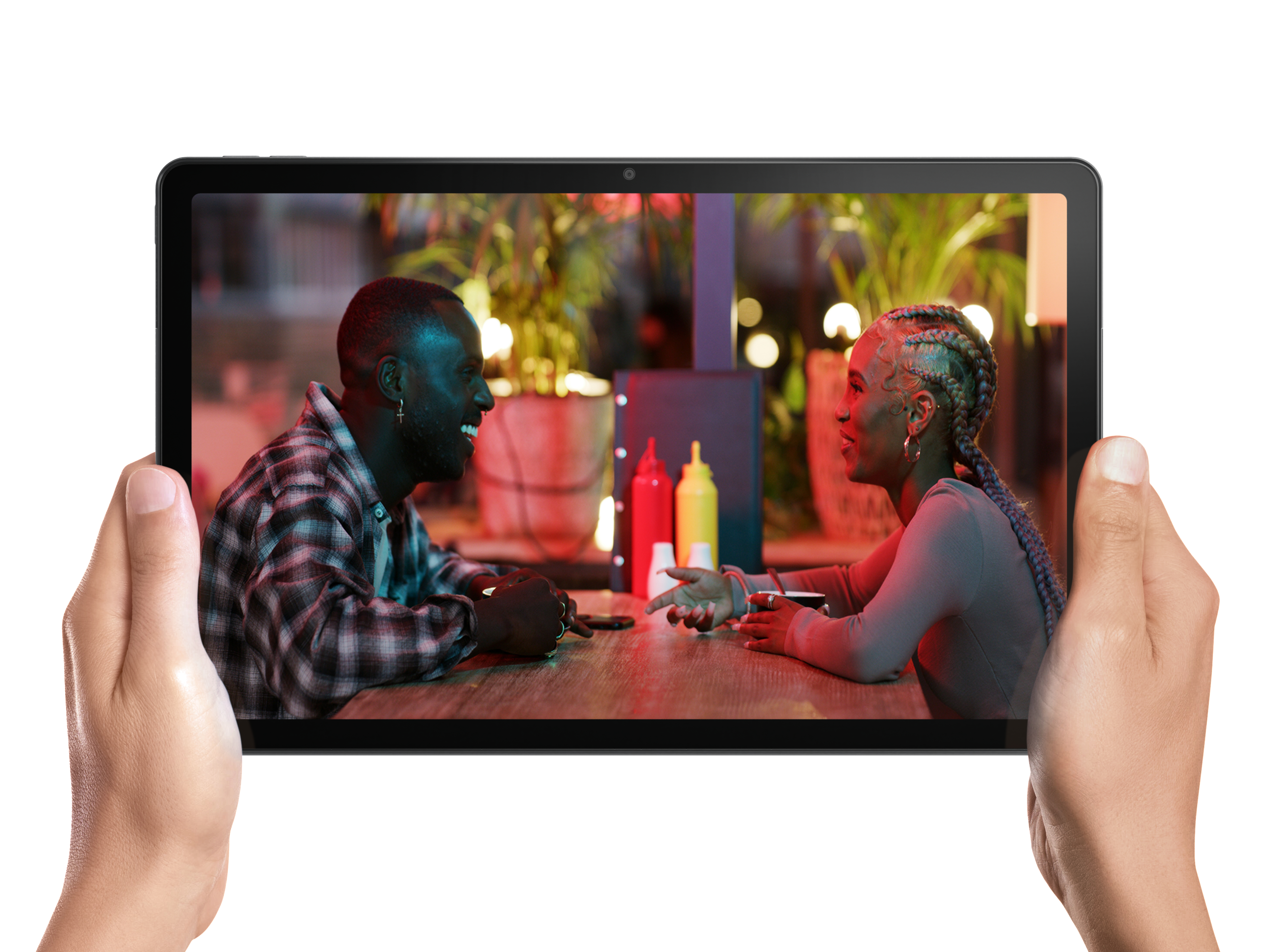 Ein Tablet zeigt ein Paar an einem Tisch in einem Restaurant, gehalten von Händen.