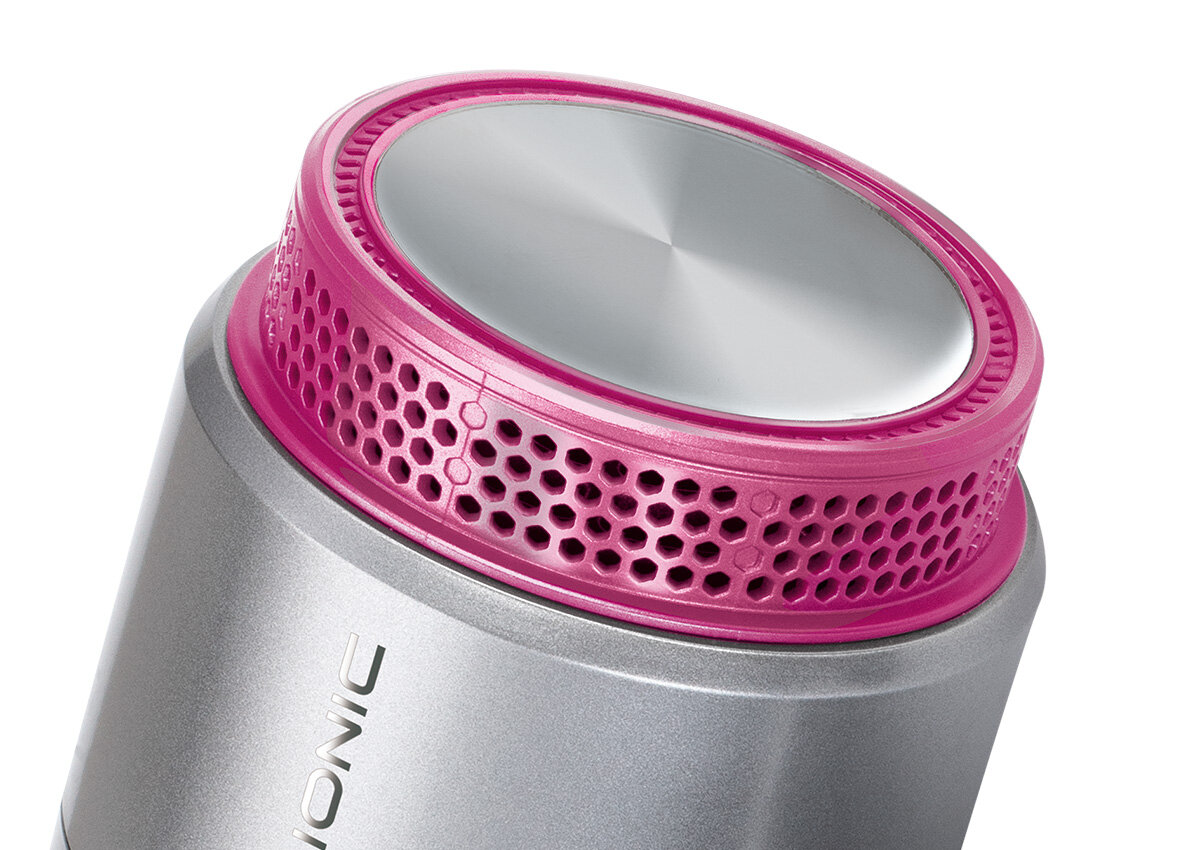 Srebrna i różowa głowica suszarki do włosów, zbliżenie na kratkę wentylacyjną.