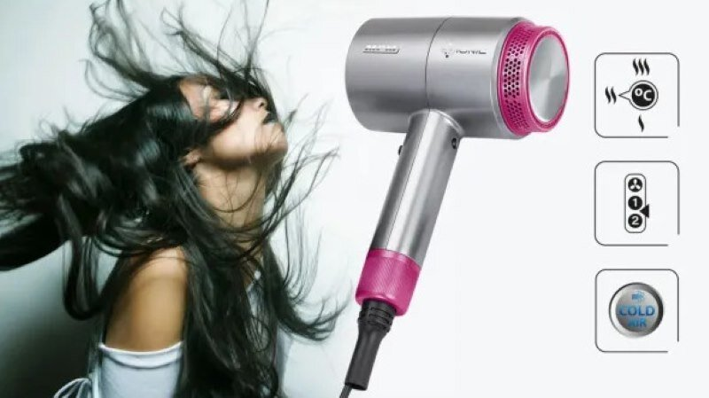 Kobieta z długimi włosami używa suszarki do włosów.