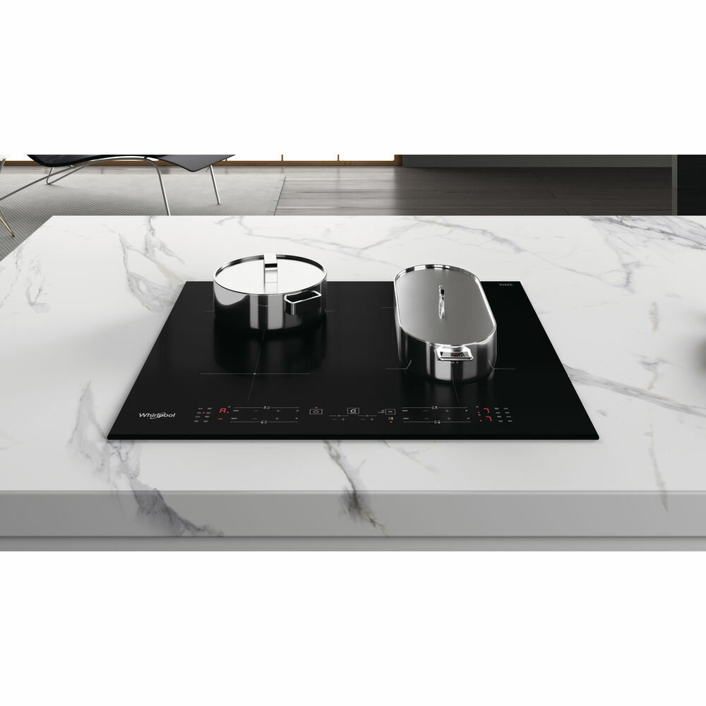 Czarna płyta indukcyjna na białym marmurowym blacie z dwoma garnkami.