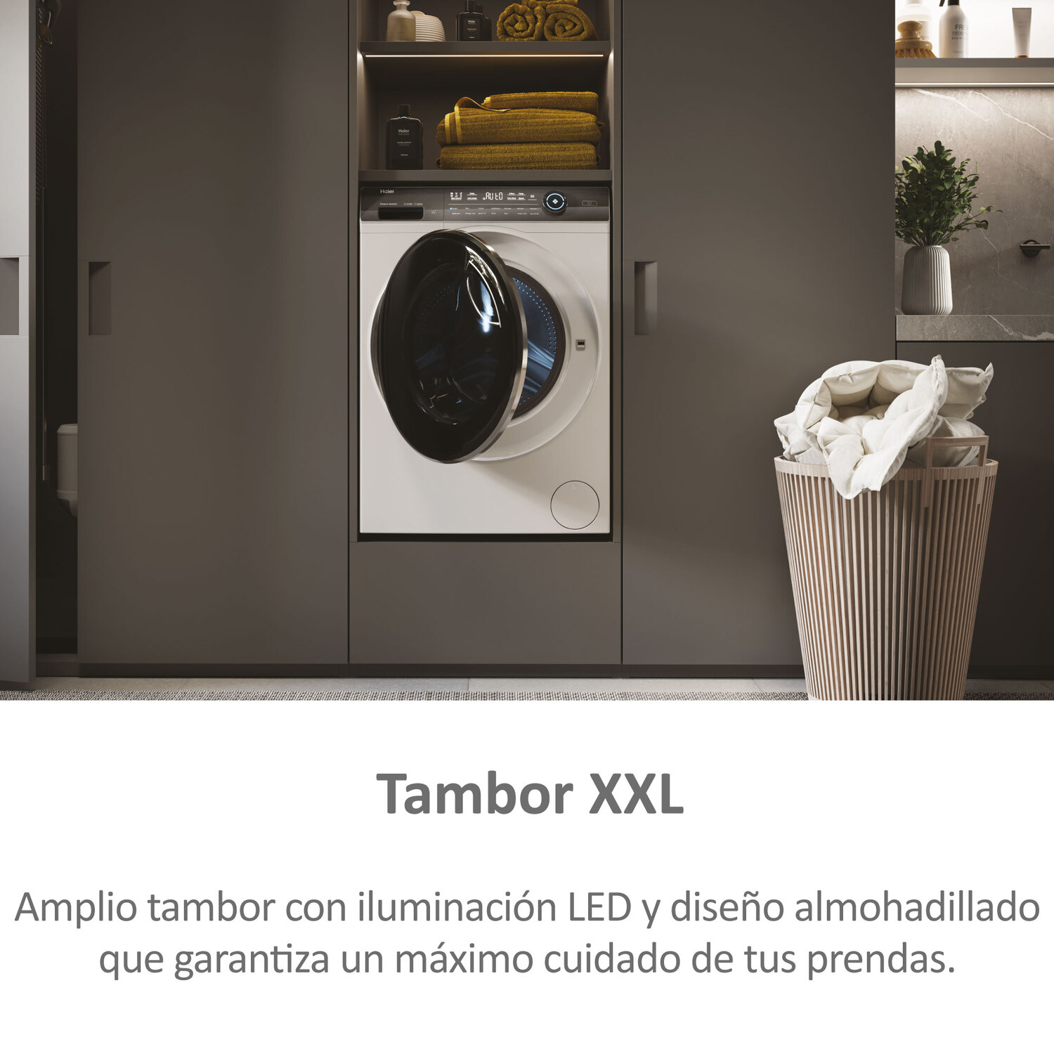 Lavadora moderna con puerta abierta y cesta de ropa cerca.