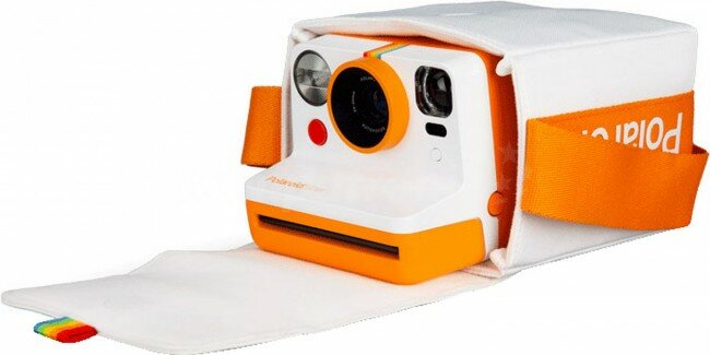 Biało-pomarańczowy aparat Polaroid w biało-pomarańczowym etui. Aparat ma tęczowy pasek.