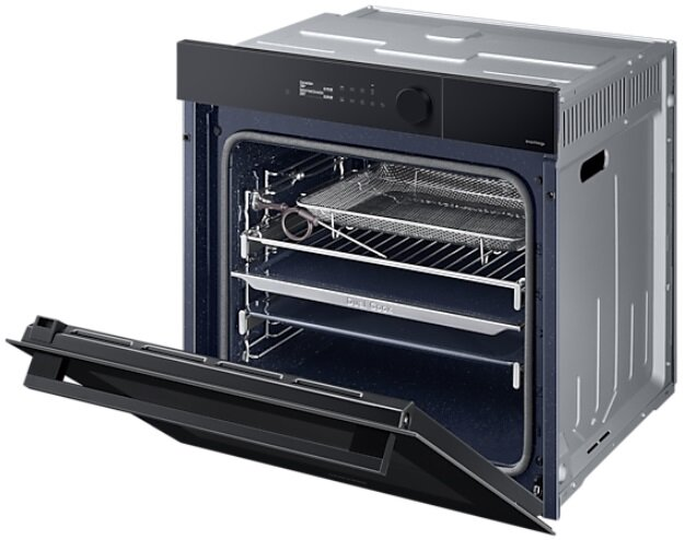 Otwarty piekarnik z półkami, tacą i uchwytem. Jest czarny i srebrny.