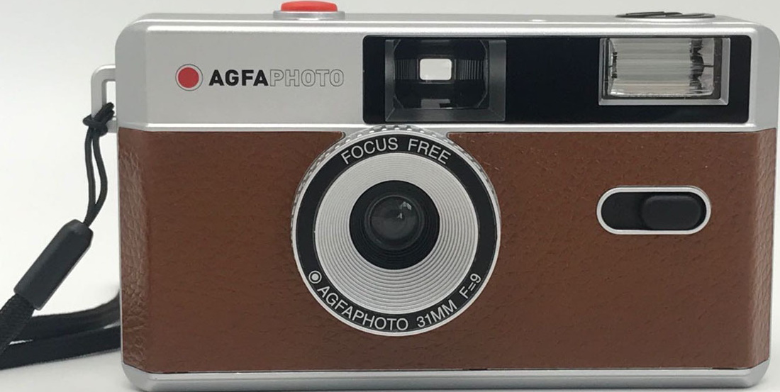 AgfaPhoto Kamera. Braunes Gehäuse mit silbernen Details, Objektiv und rotem Knopf.