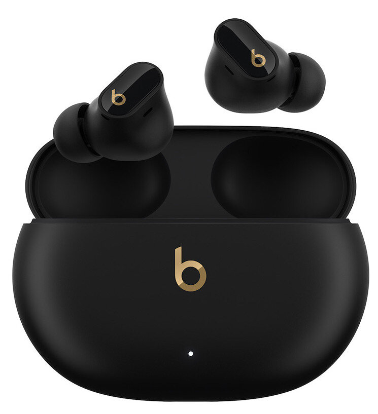 Czarne słuchawki Beats z etui ładującym. Widoczne złote logo 'b'.