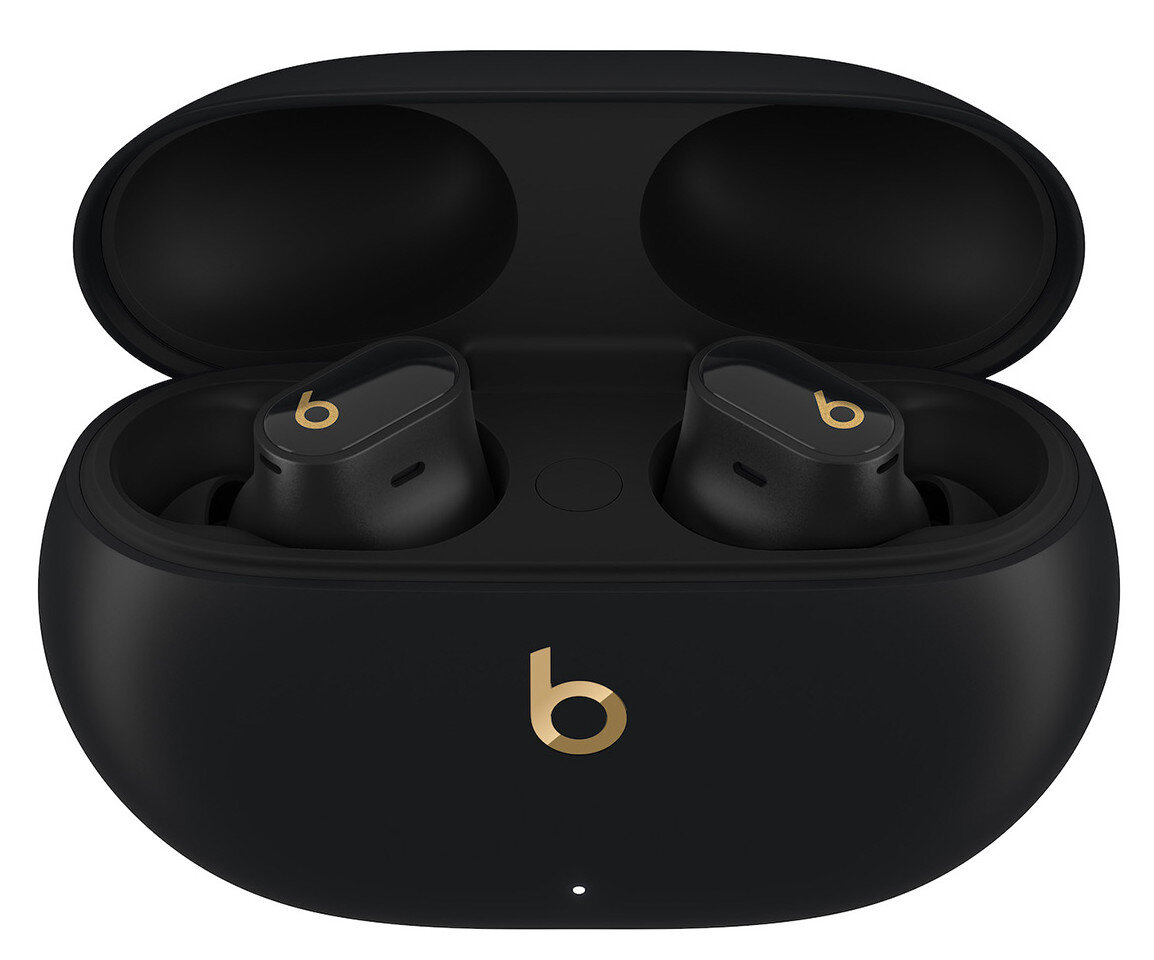 Czarne słuchawki Beats w otwartym czarnym etui ładującym, widoczne złote logo 'b', białe tło.